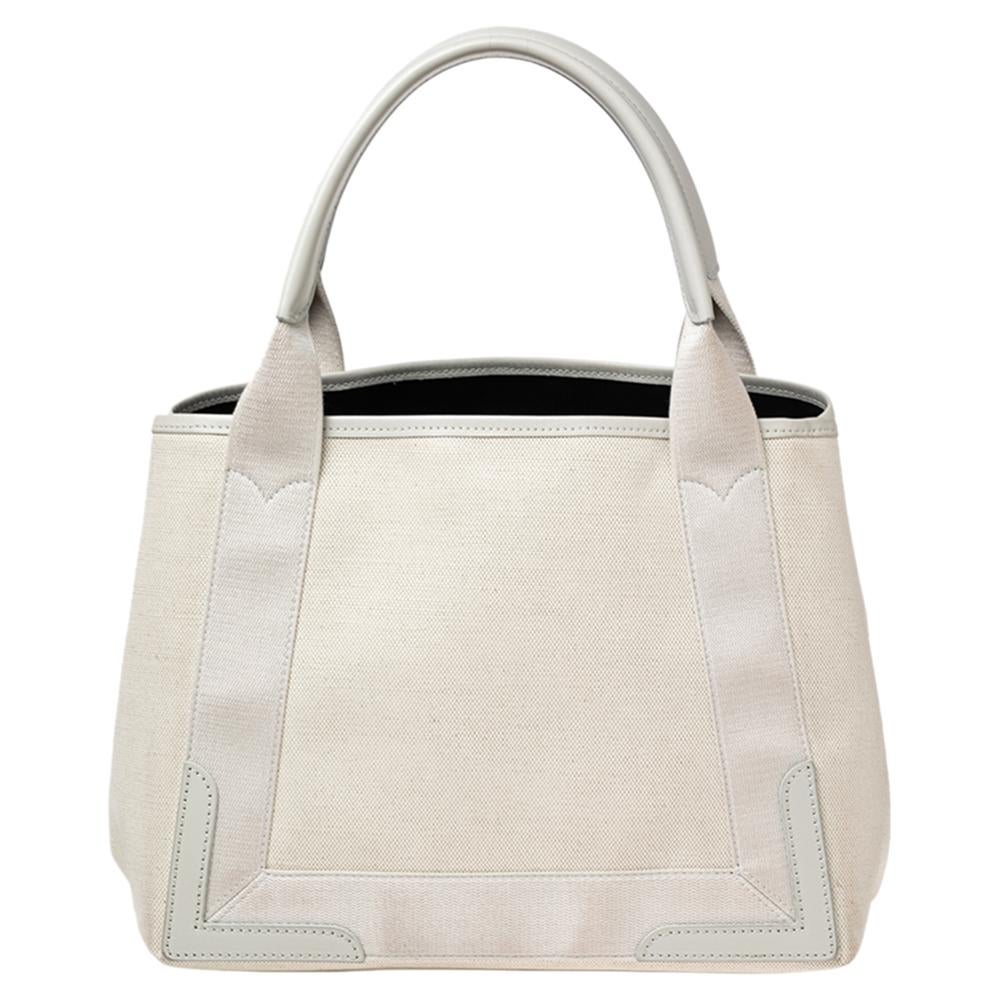 This beautifully stitched canvas and leather tote is by Balenciaga. It has a spacious size and two handles that are easy to hold. The designer tote is given a signature accent with the brand name on the front.

Includes: Detachable Zip Pouch
