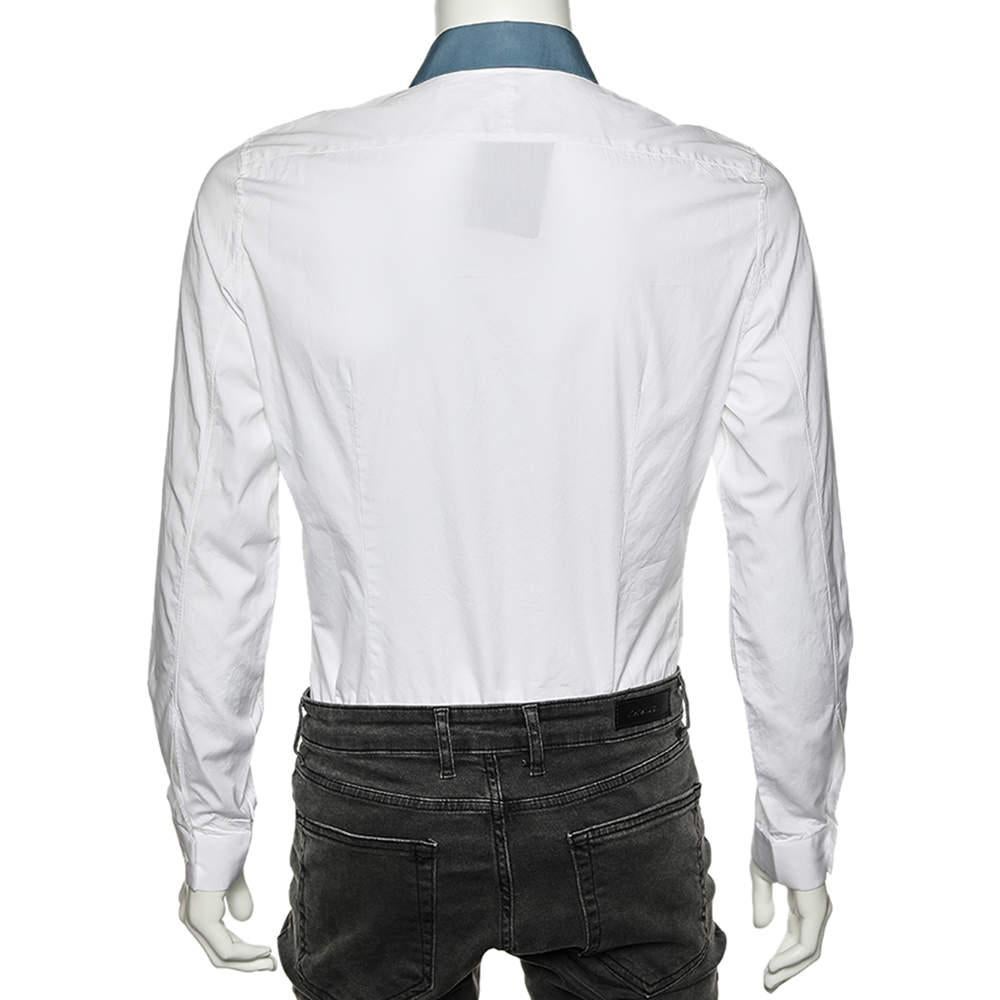 Balenciaga sorgt dafür, dass Ihr Stil für den Tag ausgefeilt und trendy aussieht. Dieses Hemd von Balenciaga ist aus weißem Baumwollstoff genäht und verfügt über einen Kontrastkragen, eine Knopfleiste und lange Ärmel. Dieses Hemd kann mit einer