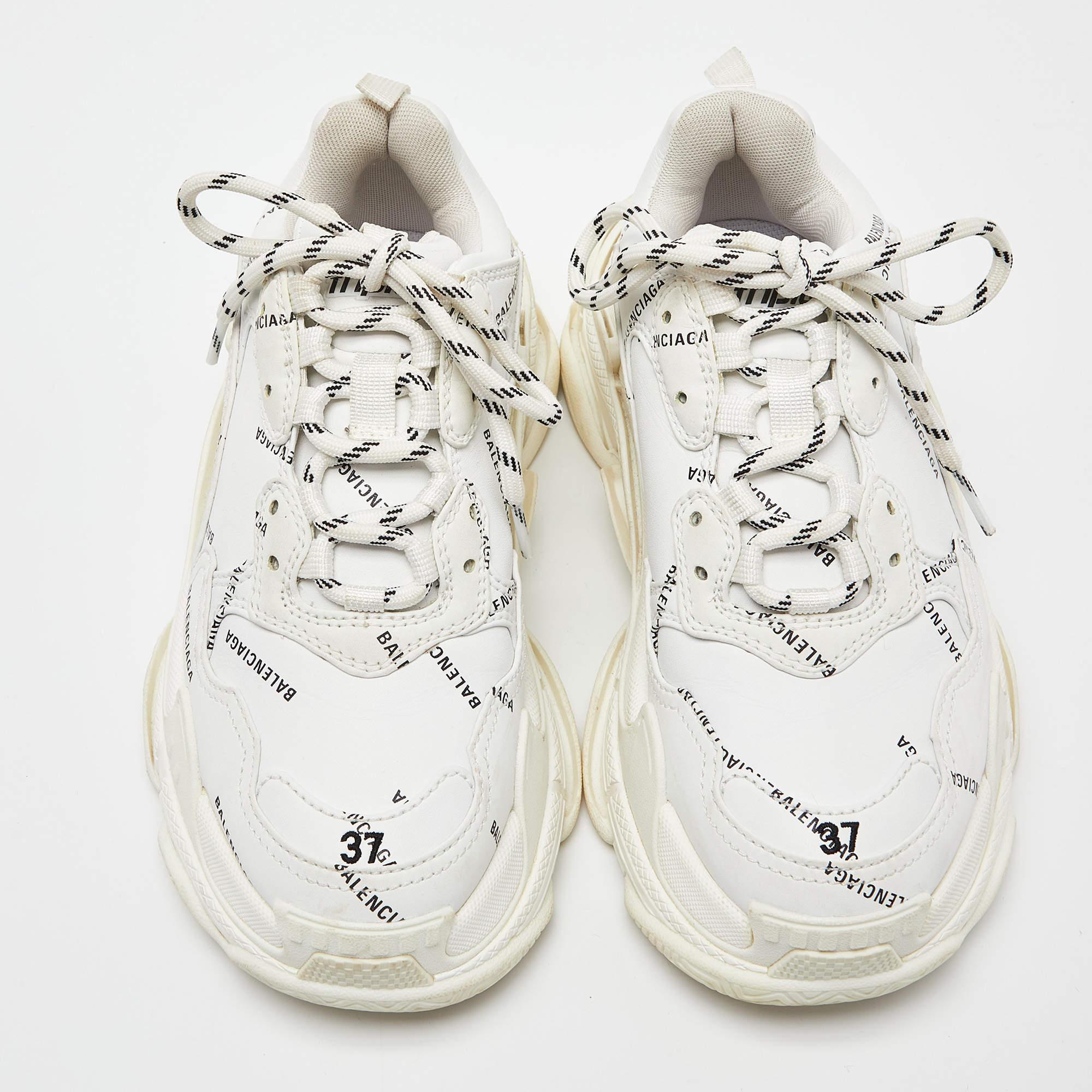 Put a modern twist on the classic kicks with these stylish Balenciaga Triple S sneakers. Featuring white faux leather, double foam, and mesh upper complimented by an allover logo print, these sneakers display embroidered size at the edge of the toe,