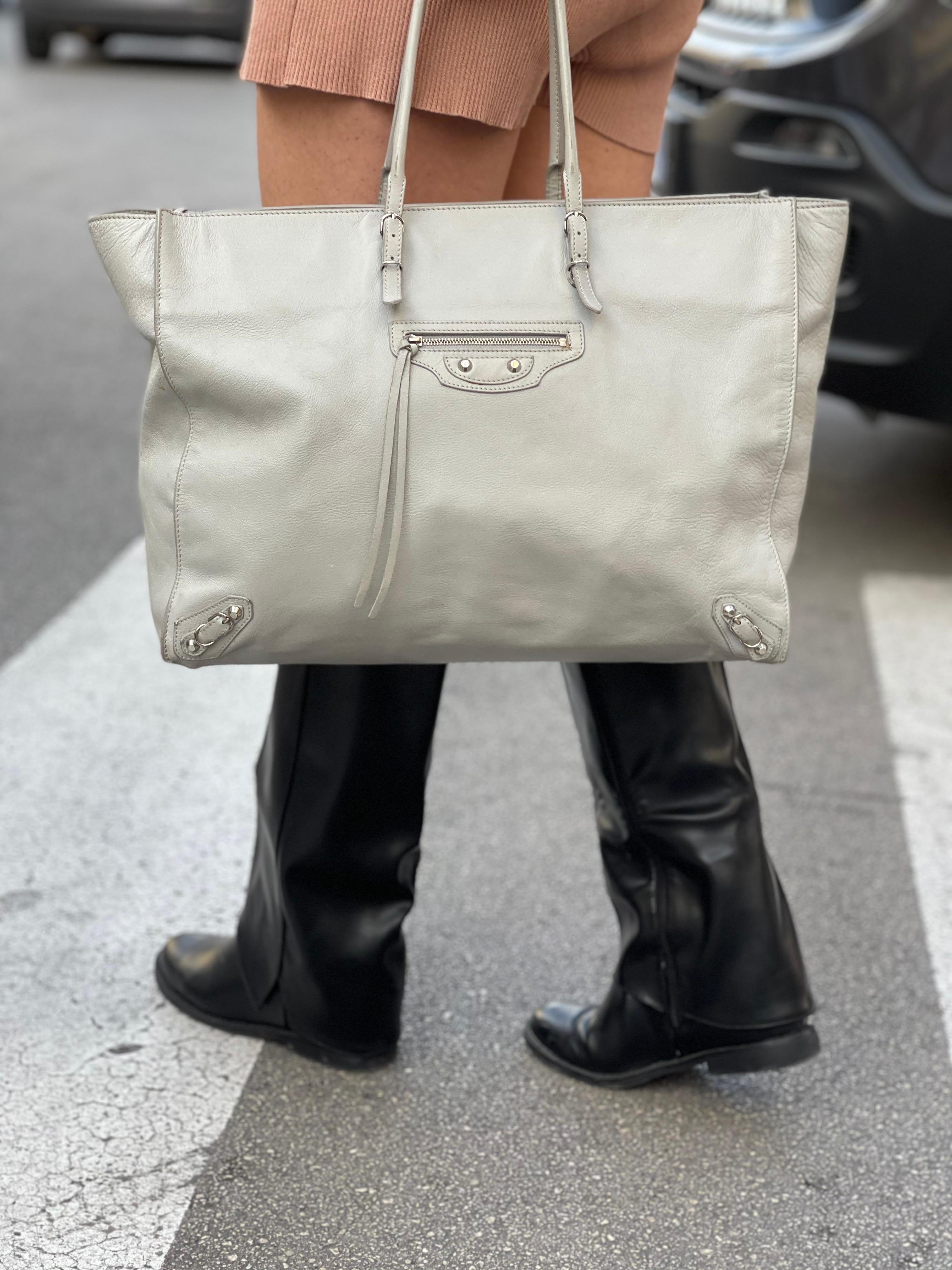 Shopping bag signed Balenciaga model Paiper large size in cement-colored leather. It features a pocket on the front, a suede interior with double pocket and a double handle to be worn on the shoulder or carried by hand.