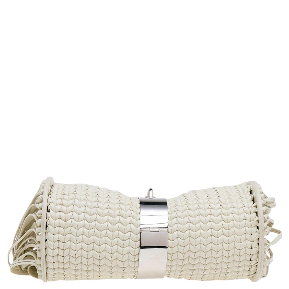 This Balenciaga clutch is a stylish creation that's sure to complement a variety of looks. Woven using white leather, the clutch has a fine construction and its appeal is elevated by the fringes on the sides and the metal lock that sits in the