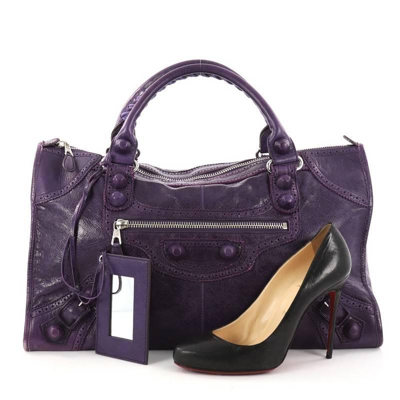 This authentic Balenciaga Work Covered Giant Brogues Handbag Leather is a stylish tote perfect for everyday use. Crafted in purple leather, this tote features signature braided top handles, perforated brogues trim details, exterior zip pocket,