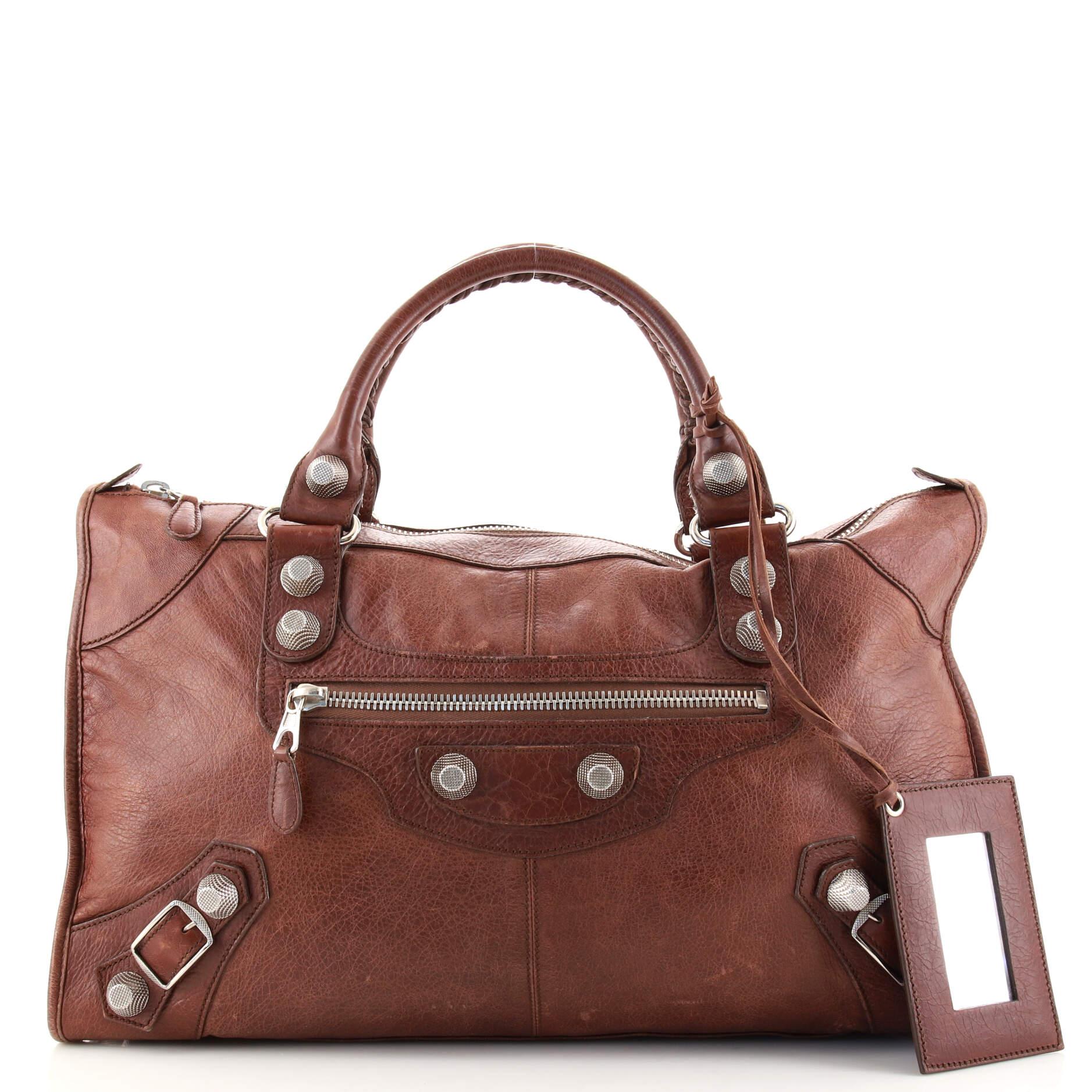Condition: Fair. Creasing, moderate wear, discoloration and scuffs on exterior and handles, cracking and splitting on handle wax edges, heavy splitting and fraying on handle base and zipper pull wax edges. Wear in interior, scratches and tarnish on