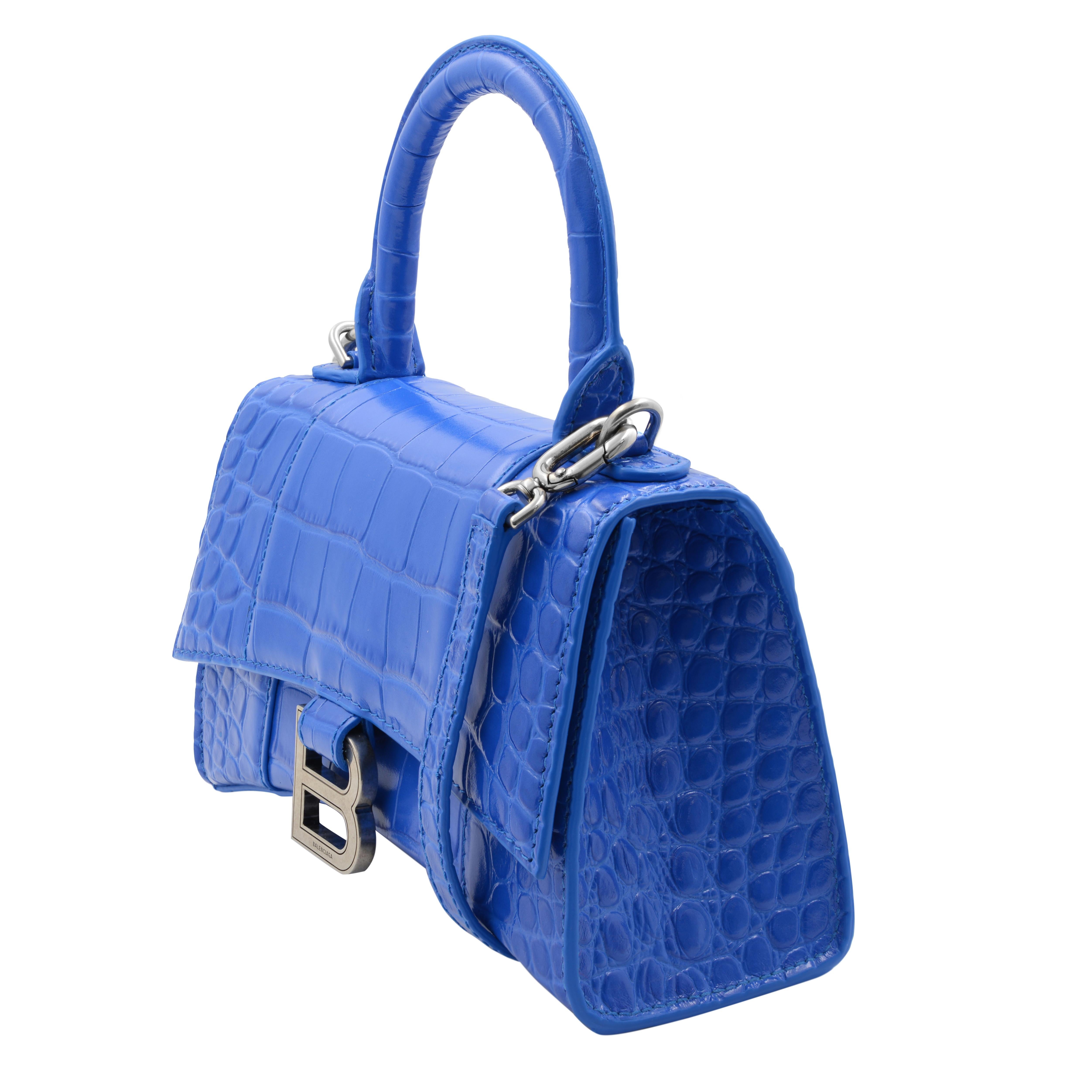 Balenciaga XS Hourglass to handle blue ladies bag. Shiny croc embossed calfskin leather with nappa lambskin leather lining and aged silver-tone hardware. Fold-over flap top closure with magnetic fastening. One main compartment. Exterior back flat