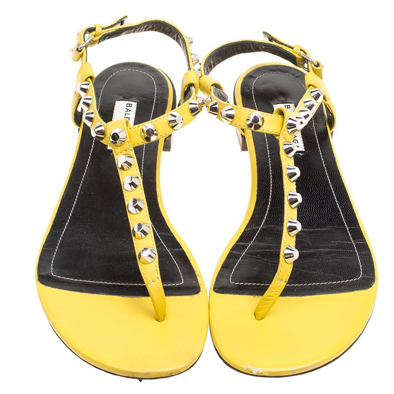 How vibrant and lovely do these Arena sandals from Balenciaga look! These yellow sandals are crafted from leather and feature an open toe silhouette. They flaunt a thong design with silver-tone studs adorning the straps. Equipped with buckled ankle