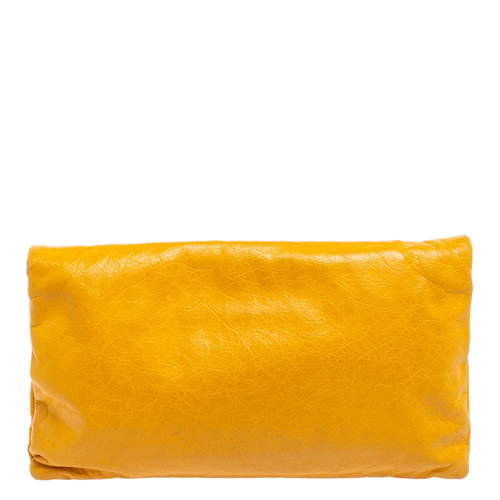 This Balenciaga clutch is perfect to carry for days when you need just your essentials. Punctuated with the label's signature studs, this envelope-style clutch features a zippered pocket on the flap and a cute vanity mirror for a touch-up. This