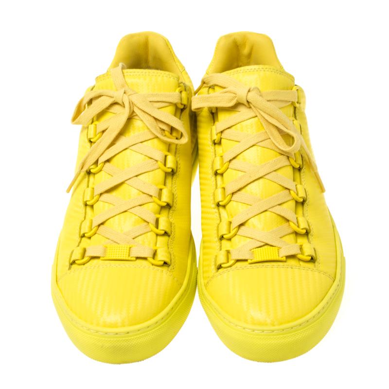 One's wardrobe is incomplete without a good pair of sneakers and what better than these Balenciaga ones! These low top sneakers have been crafted from neon yellow leather and styled with round toes and lace-ups on the vamps. They are complete with