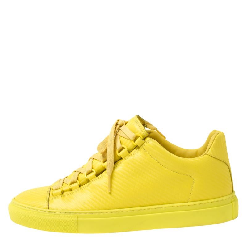 One's wardrobe is incomplete without a good pair of sneakers and what better than these Balenciaga ones! These low top sneakers have been crafted from neon yellow leather and styled with round toes and lace-ups on the vamps. They are complete with