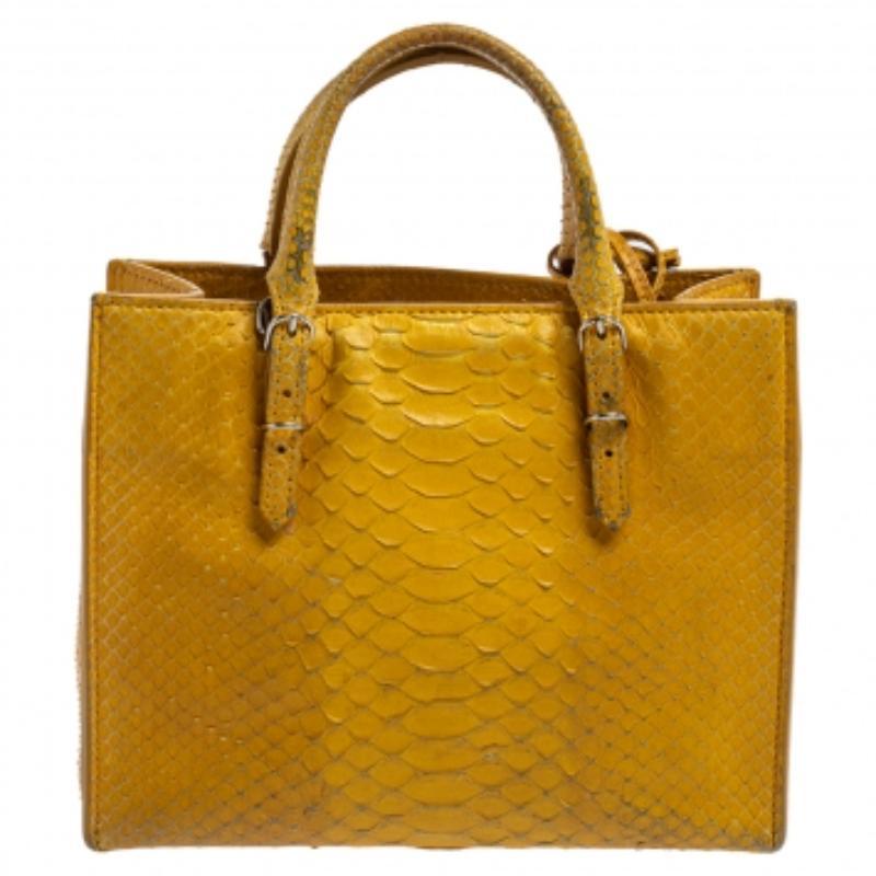 Papier A4 bag from Balenciaga smoothly blends luxury with practical fashion. It comes crafted from exotic python and styled with two top handles, a suede interior, and a detachable mirror. But it is the zippers and buckle detailing which makes the
