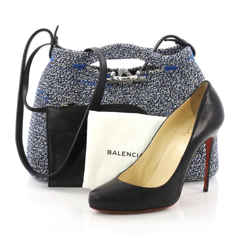 This Balenciaga Zigzagger Handbag Woven Fabric, crafted in blue woven fabric, features dual handles, zigzag stitching, and silver-tone hardware. It opens to a blue woven fabric interior. **Note: Shoe photographed is used as a sizing reference, and