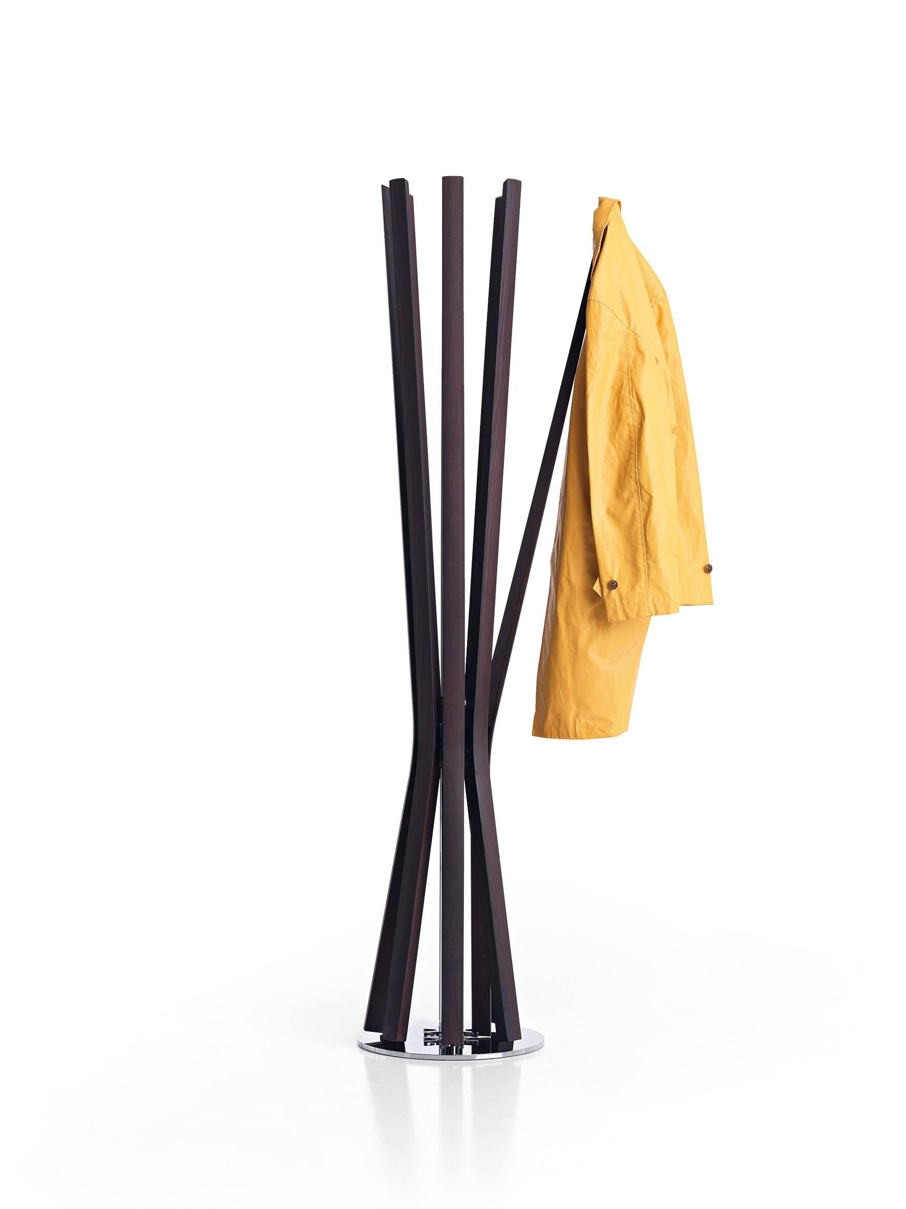 Coat-hanger with chrome steel structure and eight arms made of moka ashwood. The Bloom coat hanger can rotate around the central stem allowing easy access to each of the arms which open individually when weighted with a coat and close when clothing