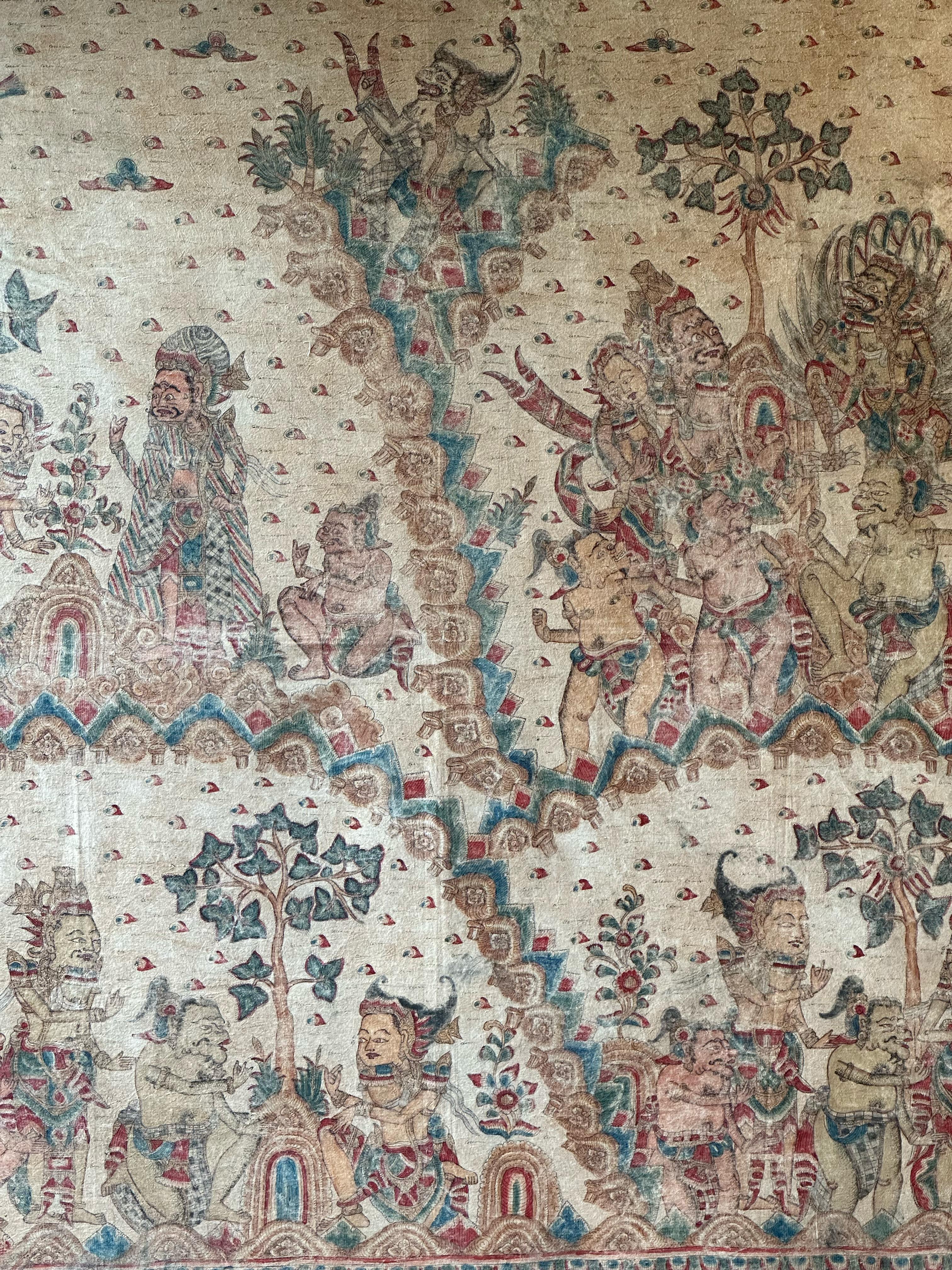 An early 20th century 'Kamasan' cotton textile painting from Bali, Indonesia. The hand-painted image has great detail and depicts Balinese Hindu mythology. It is stretched over a canvas, bordered by a teak wood frame and is ready to be wall mounted.