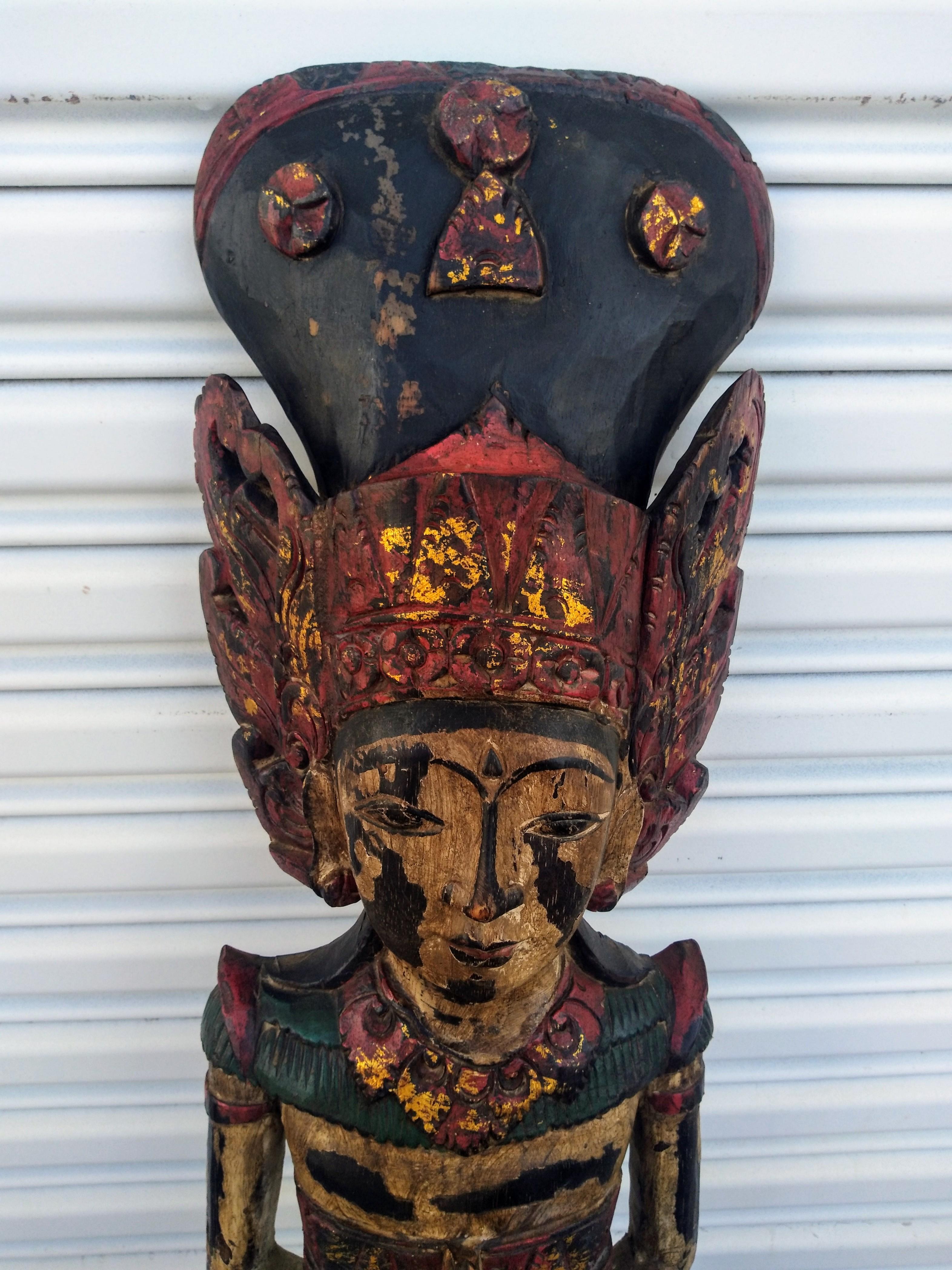 Dies ist eine schöne Holzskulptur einer balinesischen Gottheit. Es ist handbemalt, um dem Holz eine gealterte Patina zu verleihen. Elegant geschnitzt, zeigt es die Handwerkskunst der balinesischen Schnitzer.