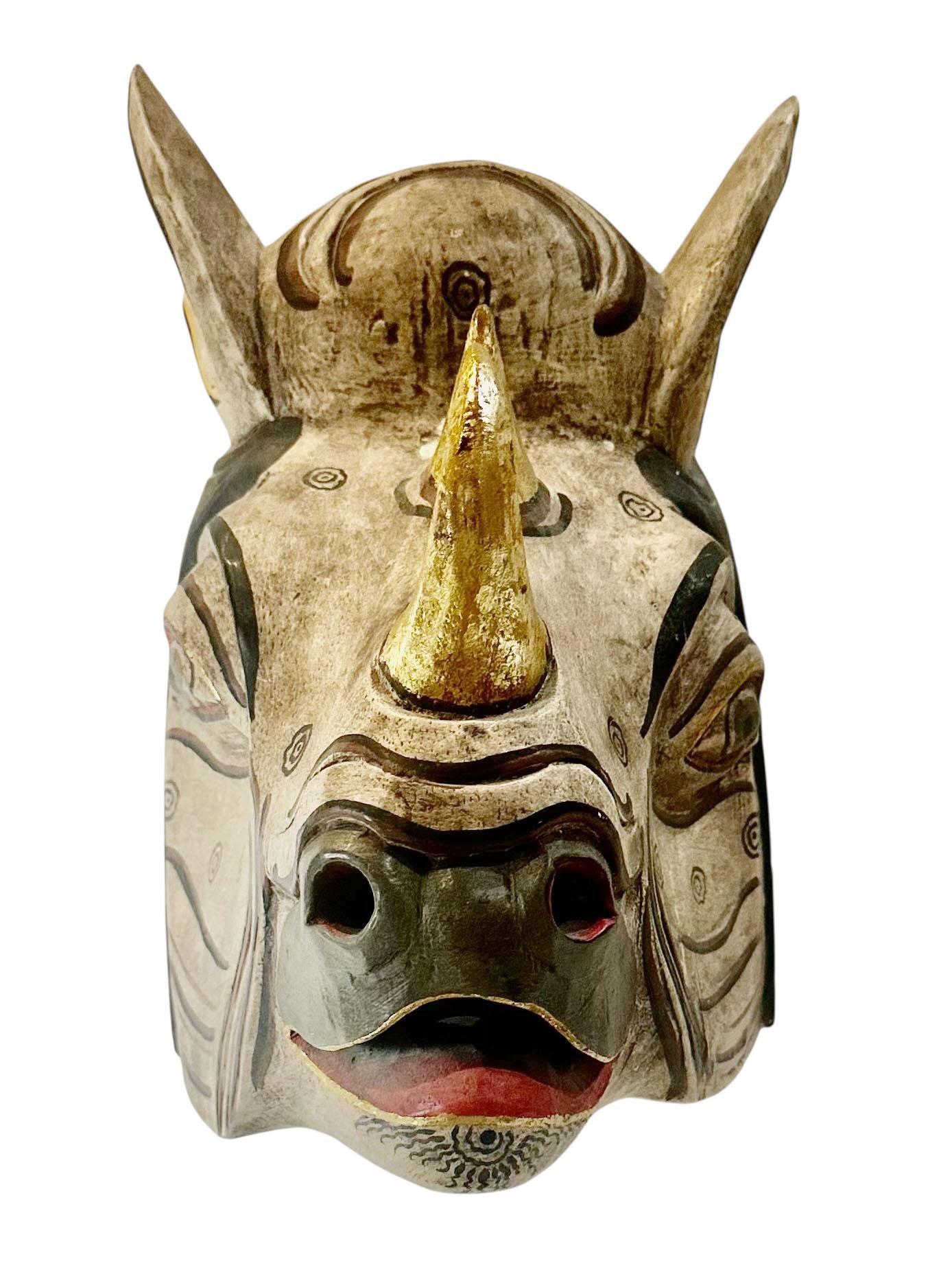 Maschera vintage balinese in legno intagliato a forma di rinoceronte, dipinta a mano con dettagli vivaci. Risalente agli anni '70 circa, questo pezzo riflette le tradizioni teatrali e decorative dell'arte balinese.

Il corno è stato rifatto a un
