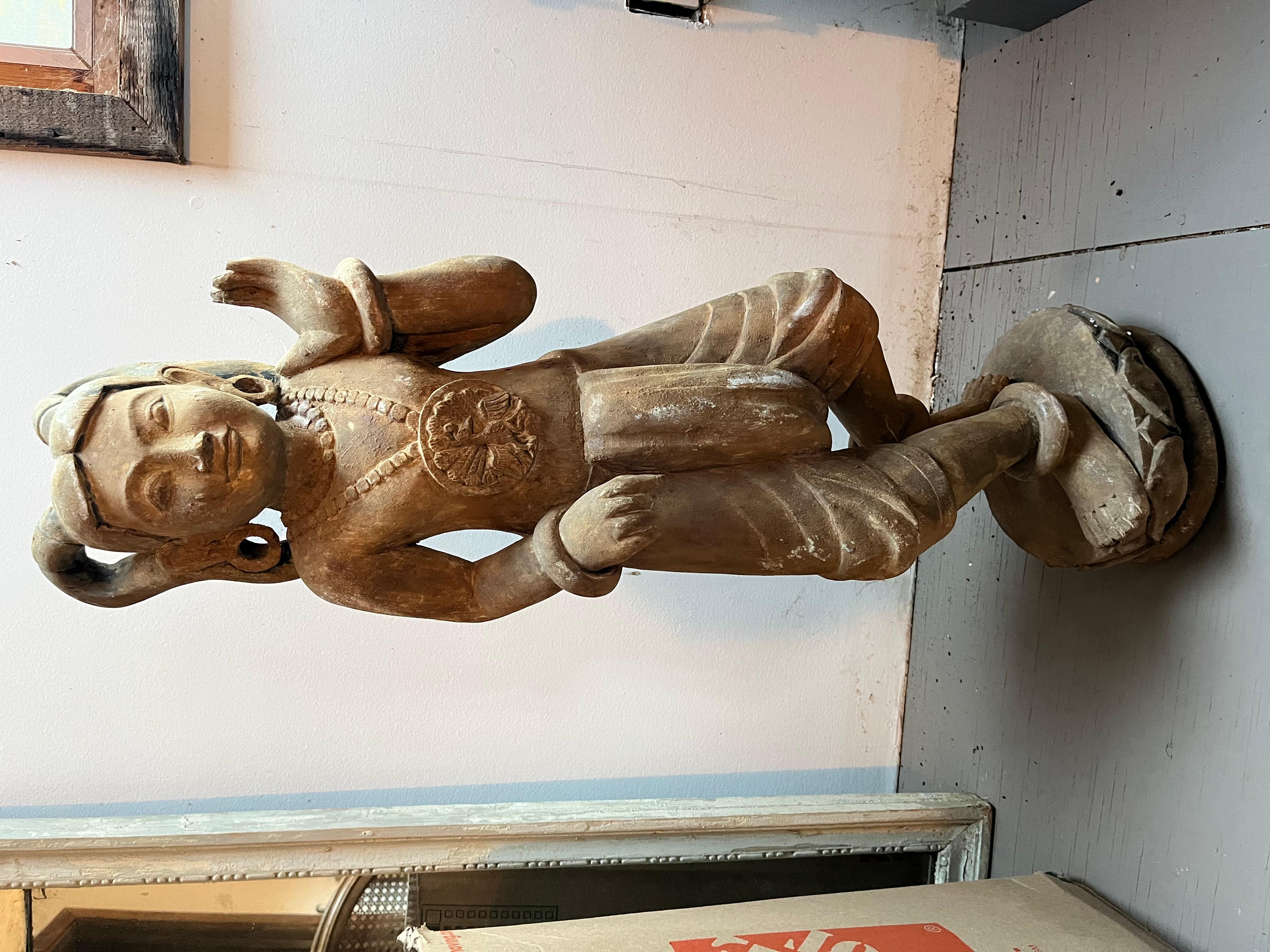 Statue en bois sculpté d'une danseuse balinaise en tenue traditionnelle, fin XIXe-début XXe siècle. Conserve une grande partie de sa finition peinte d'origine.