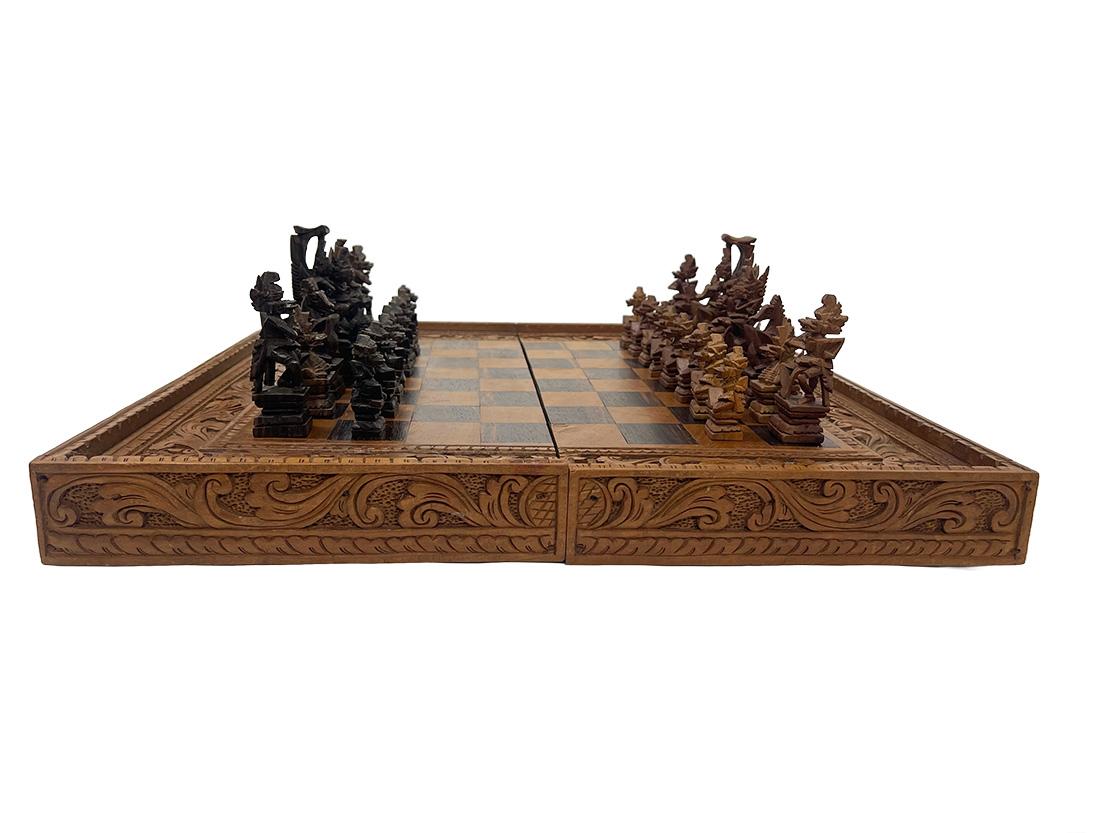 Balinese Chess set in box, 20th Century

A chess set in a box, this hand-carved wooden set with Balinese various Deities, Idols, and Demons, in a large wooden casket carved from Teak wood. The box, which is collapsible into a half part, is also