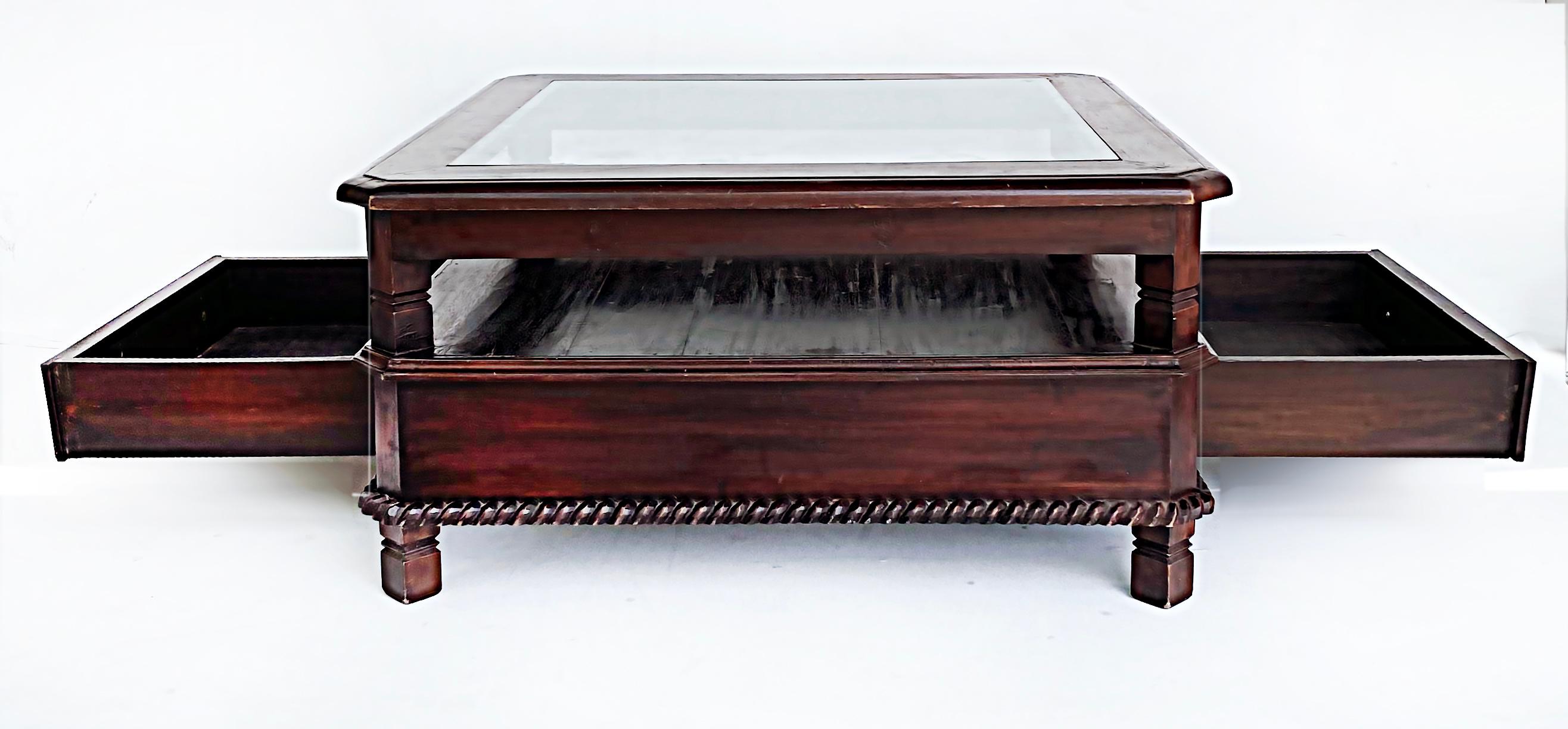 Balinese Mahogany 2-tier 2 drawer coffee table with inset glass top 

Offered for sale is a Balinese mahogany two-tiered coffee table with an inset glass top and two drawers. The frame is hand-carved with a rope border and detailed legs and feet.