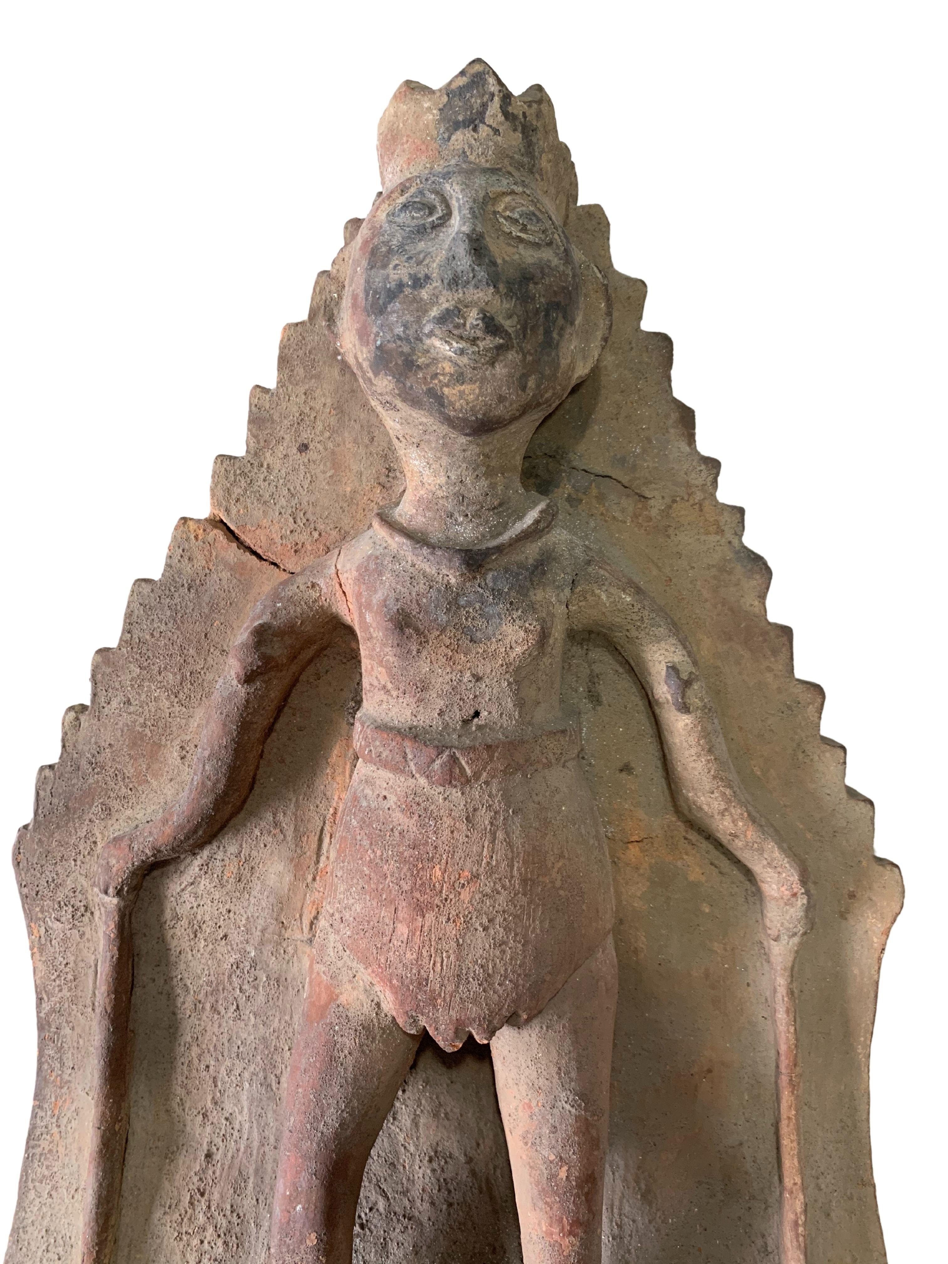 A Balinese terracotta panel that once adorned a Hindu temple. The panel depicts a male figure semi-robbed with a sarong (a garment consisting of a long piece of cloth worn around the body). The panel's figure features defined facial features and a