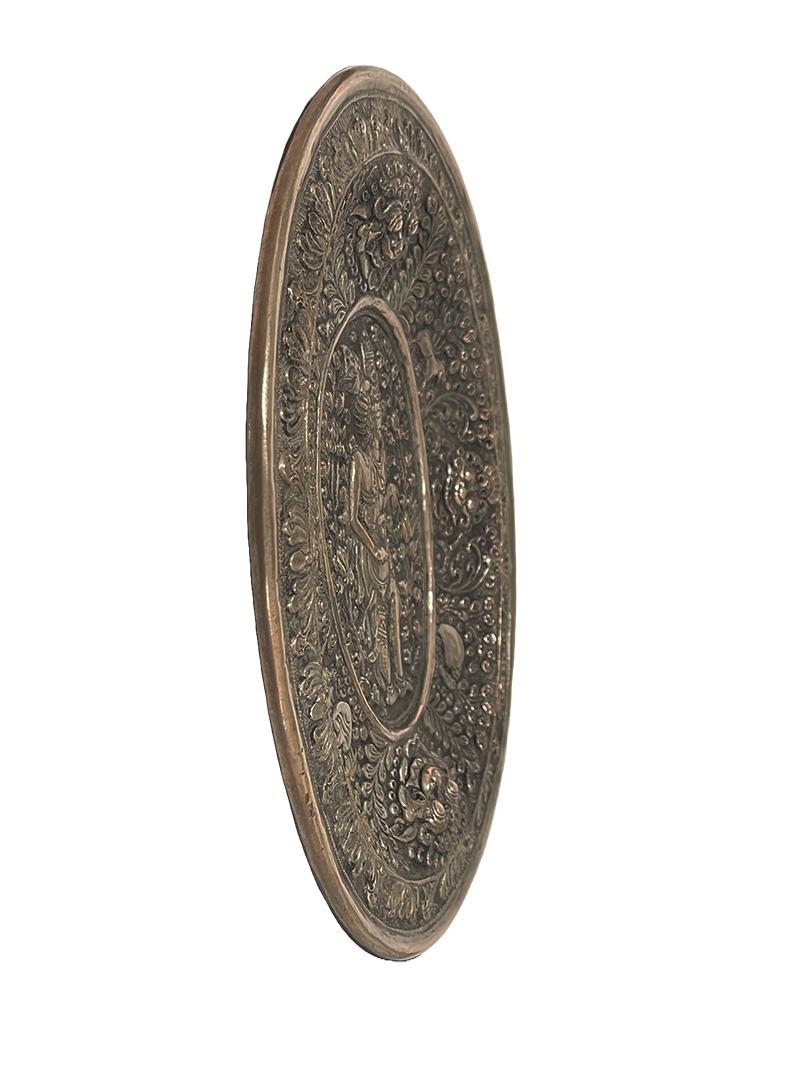 Balinese Yogya silver oval dish with scene of an Indonesian God and animals

An oval Indonesian Yogya dish from Bali, late 19th Century with in the center a scene of a God, surrounded with plants and flowers. Beautifully decorated with Kala heads (a