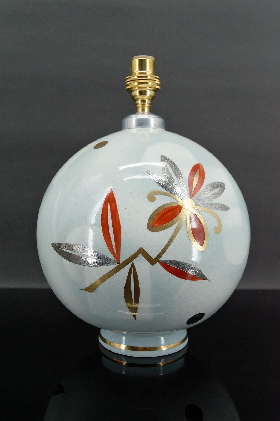 Ball lamp by the Faïencerie de Sainte Radegonde for Primavera.
Art Deco, France, circa 1925

In white ceramic, decorated with stylized flowers in red, gold and silver tones.

Art Deco, France, circa 1925.

In excellent condition, new