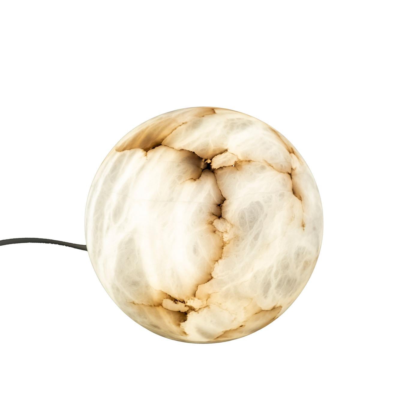 Natural round-shaped alabaster table lamp. The veins are the main characteristic of alabaster stone, ranging from white to brown. When the lamp is turned on, all the various nuances are highlighted, making the lamp a unique piece that enriches the