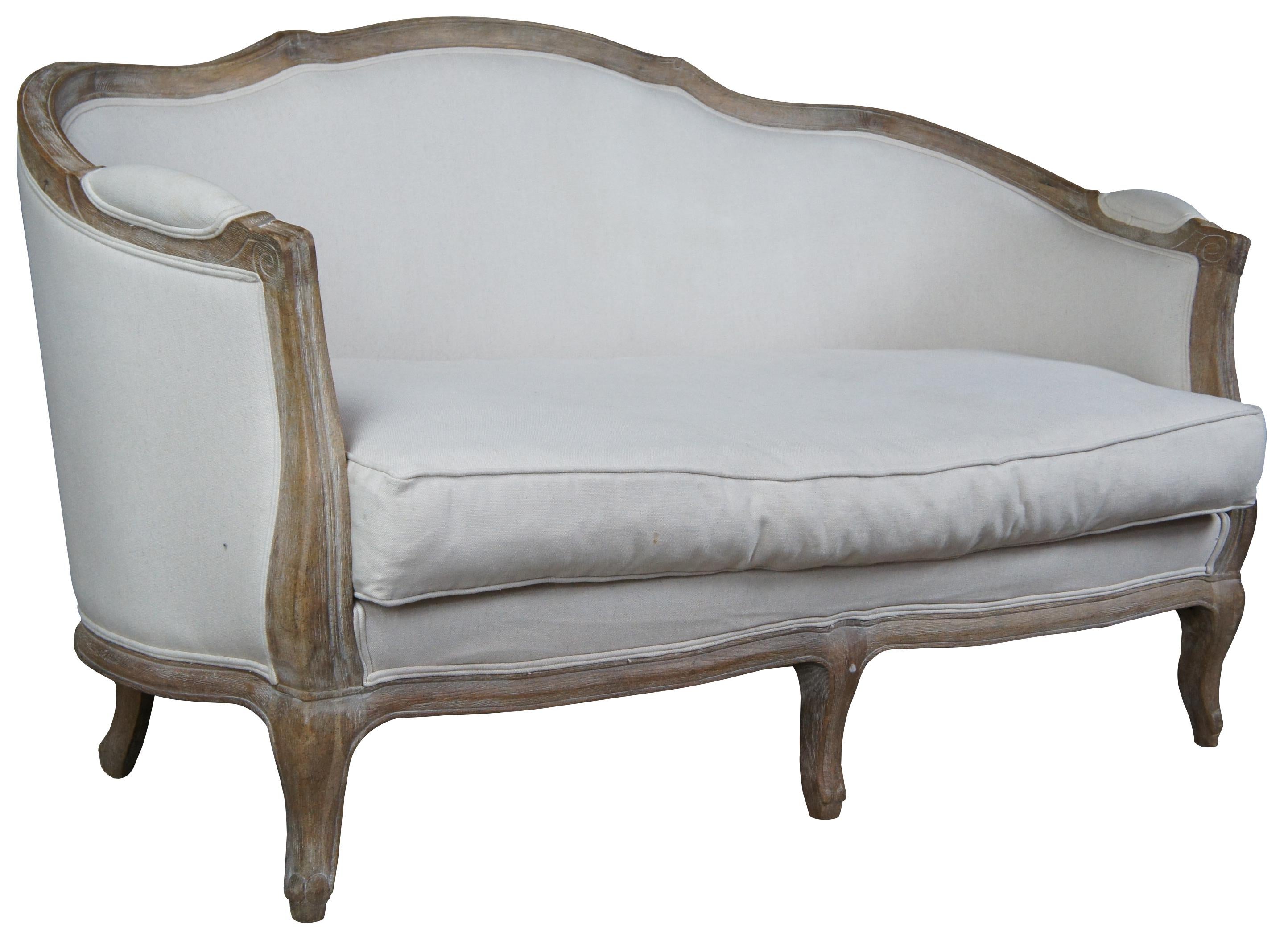 With its perfect proportions and cushioned, wrap-around back, this French settee creates a cozy retreat for a bedroom or sitting room. Limed finished, solid oak frame is crafted in the classic Louis XV style with fluted scrolling arms, serpentine