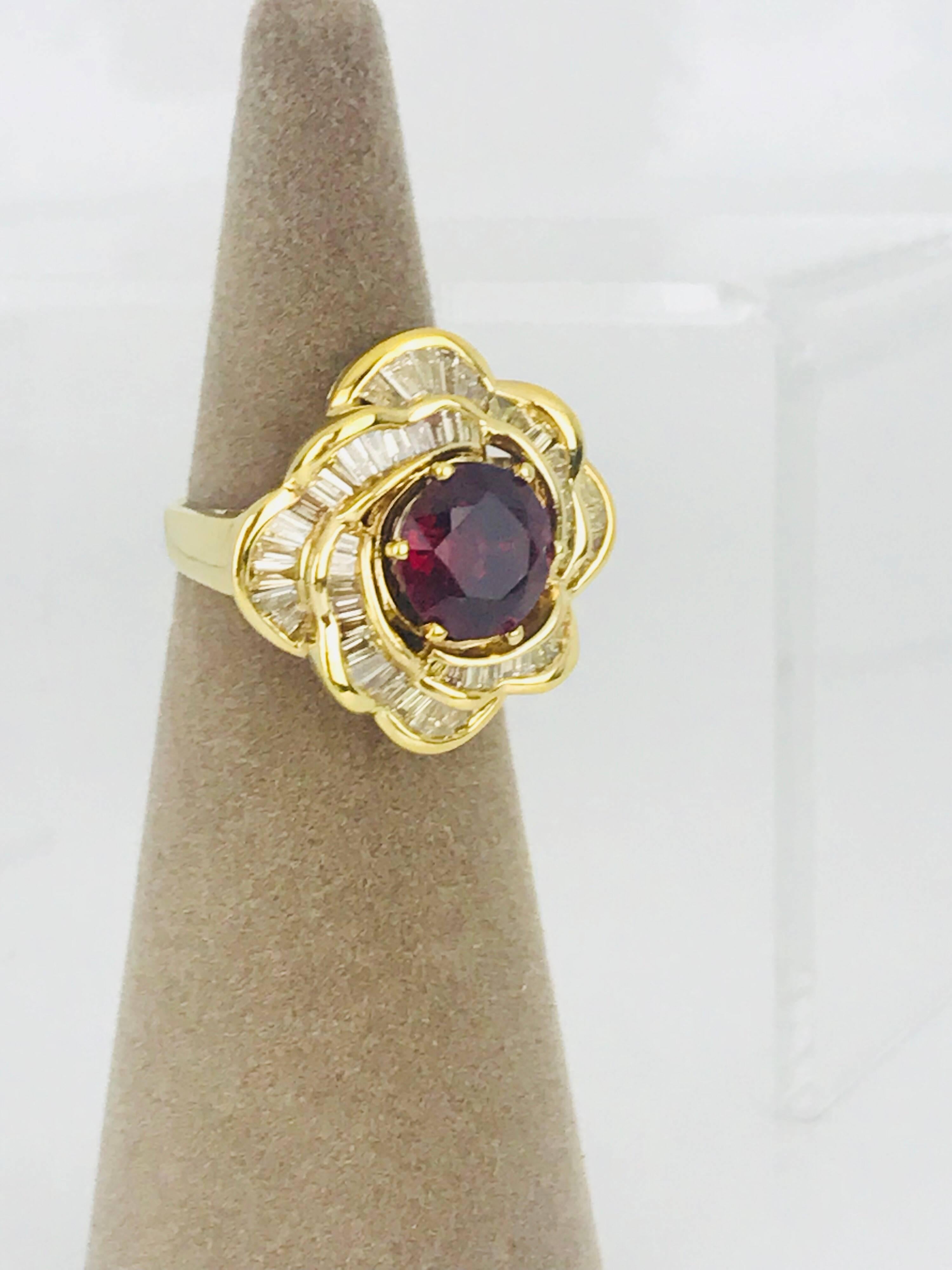 18 Karat yellow gold diamond, Ballerina-style ring. The center is a round brilliant cut Rhodolite garnet with 64, surrounding tapered diamond baguettes. 

The total diamond weight is approximately 3.00 carats. 
The quality of the diamonds are