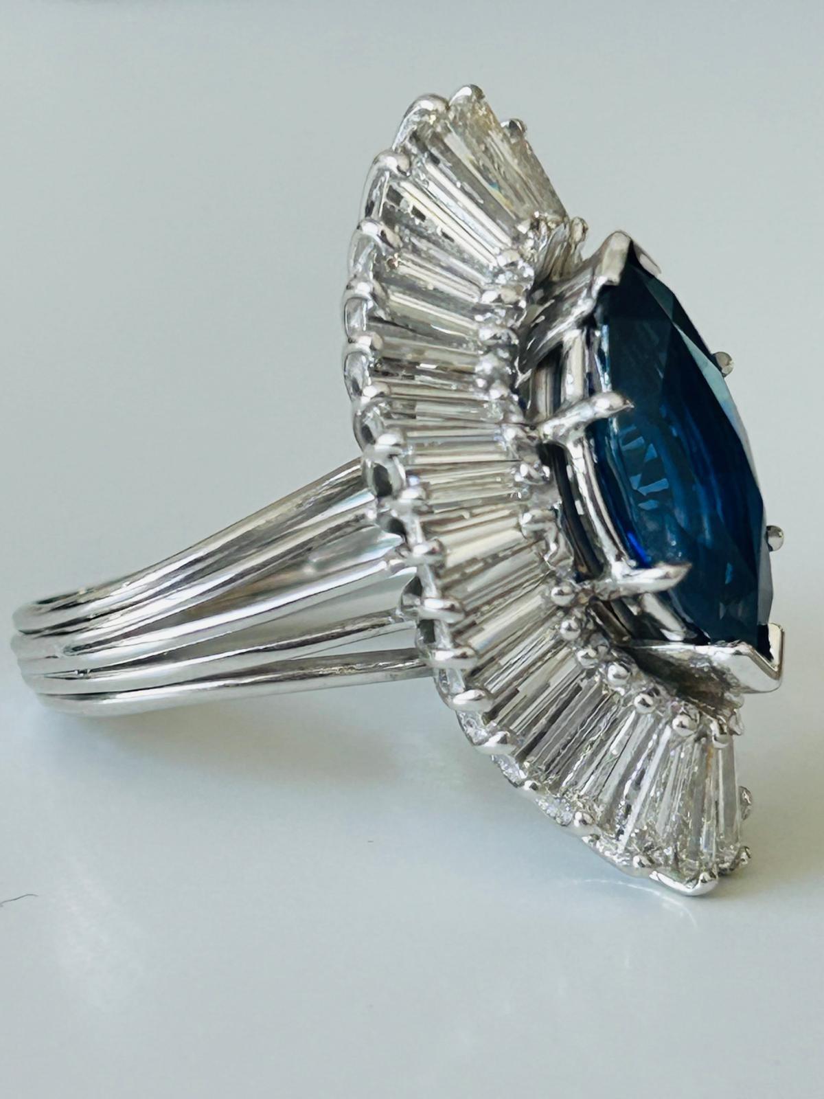 Uno squisito anello Ballerina con zaffiro e diamante, sapientemente realizzato in lussuoso platino. Il cuore di questo gioiello è uno splendido zaffiro naturale certificato di 3,65 carati con taglio a marquise, di colore blu reale: un vero e proprio