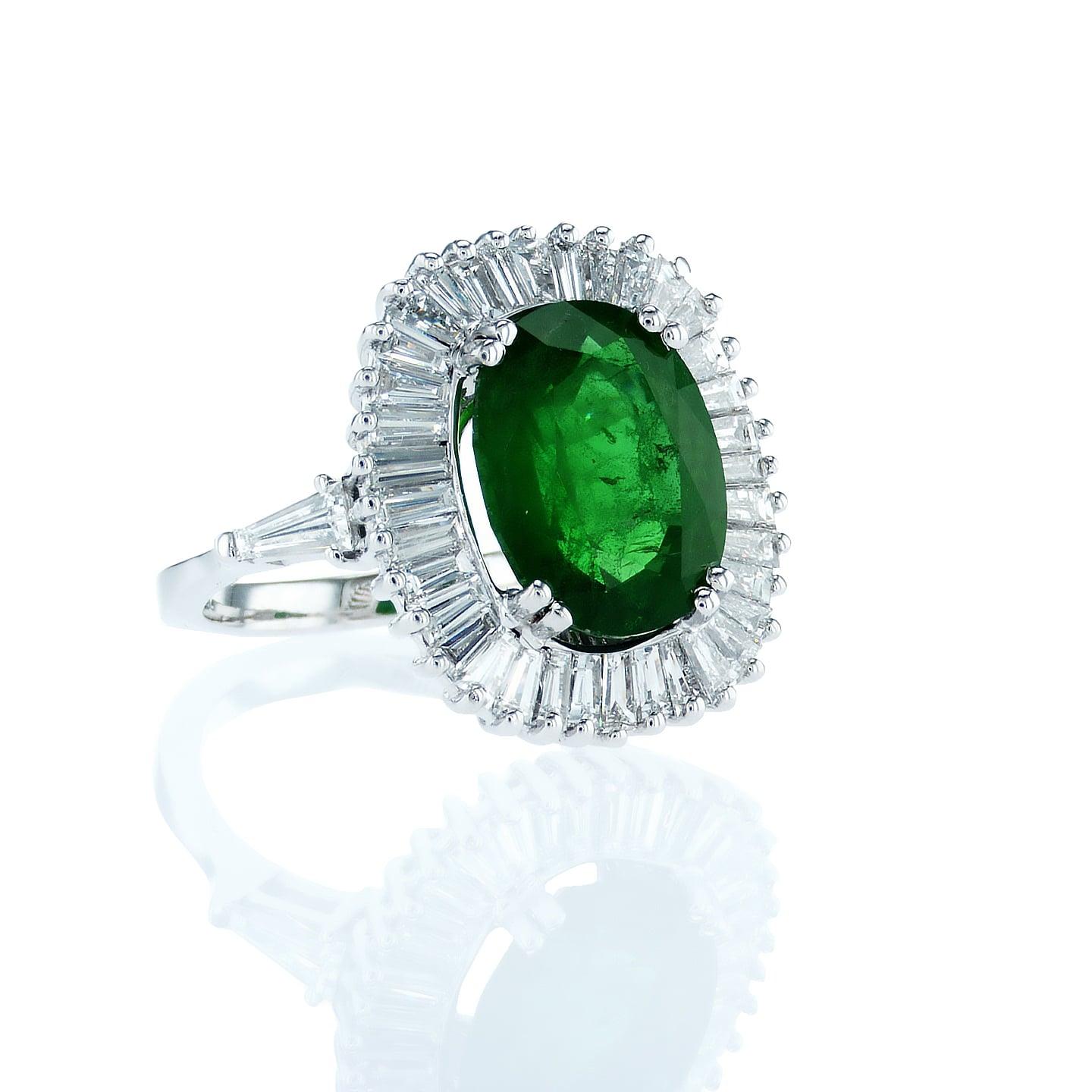 
Hand Crafted Ballerina Style ring featuring an oval 4.32 Carat Natural Green Emerald as a center stone and accompanied by 38 high quality tapered baguette shaped diamonds 1.77 Carat TDW.  This magnificent ring is made with precise detailed