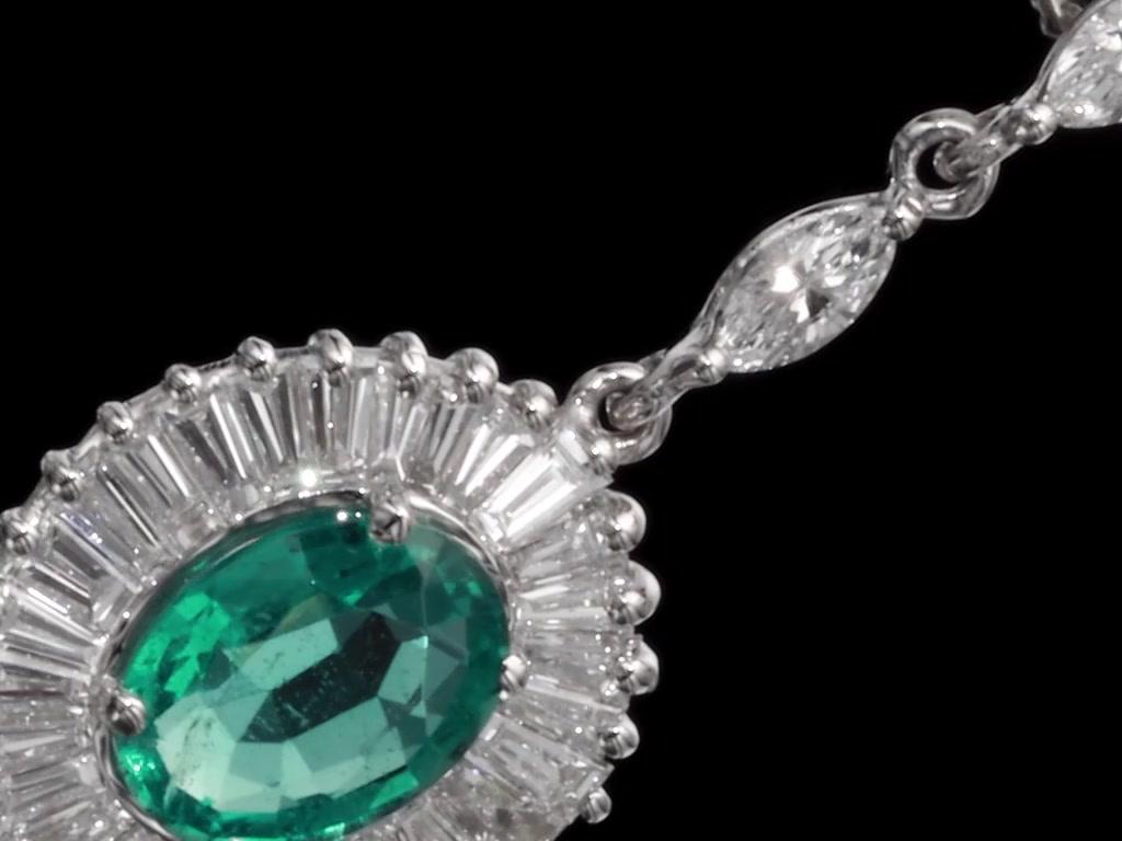 Orecchini di smeraldi e diamanti in stile ballerina, unici nel loro genere, con 2 smeraldi naturali da 2,12 carati totali. Questi splendidi smeraldi sono circondati da 56 diamanti taglio baguette e 12 diamanti taglio marquise. Come mostrano le