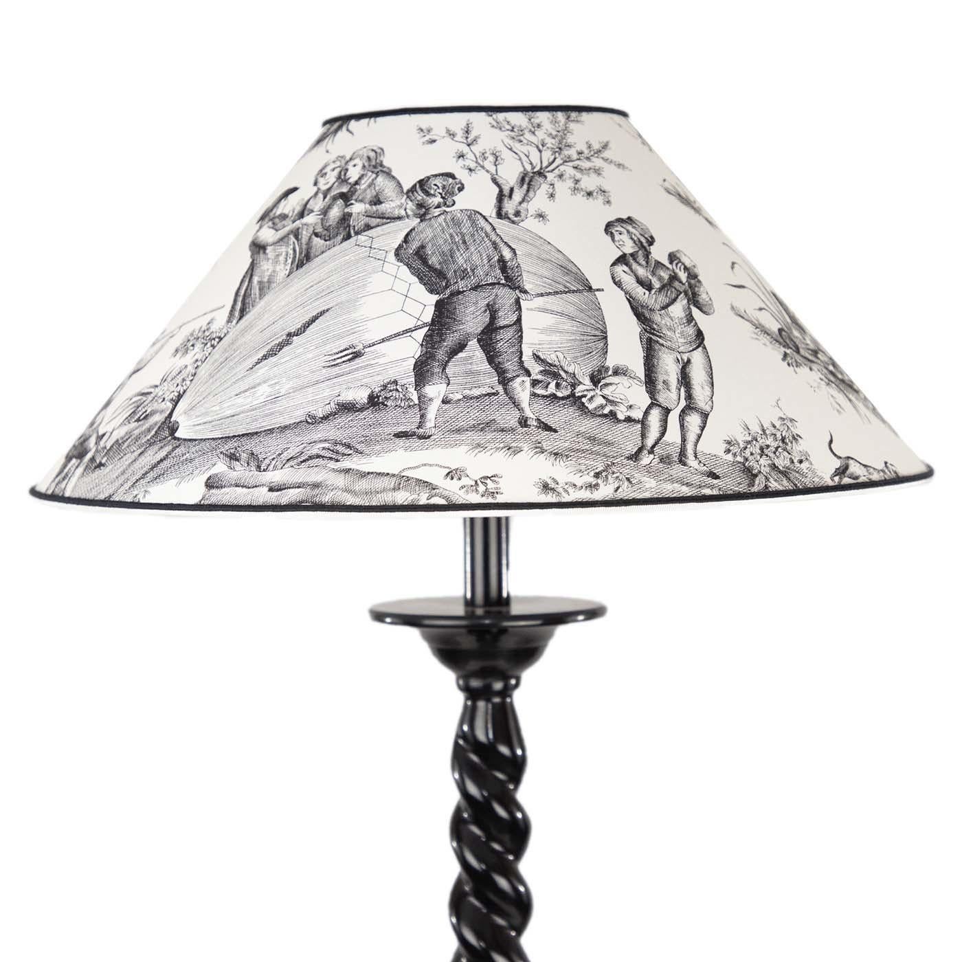 From the Peca Italia Collection, the Ballon de Gonesse Lamp features a torchon black metal base and a cone-shaped lampshade in fabric printed with a delightful, original French classic toile de jouy. By purchasing a pair of lamps, one can be placed