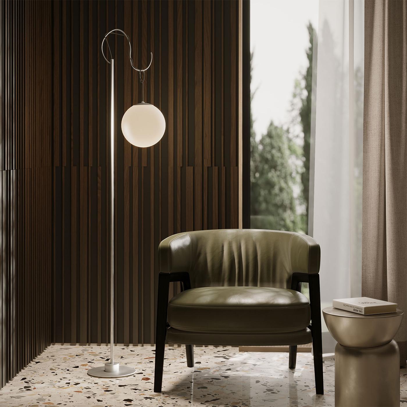 A captivating design that embodies the fusion of solidity and lightness. From the slender silver stem emerges a wire, artfully integrated into the design, that suspends the matte glass sphere, emitting an inebriating glow. A celebration of the
