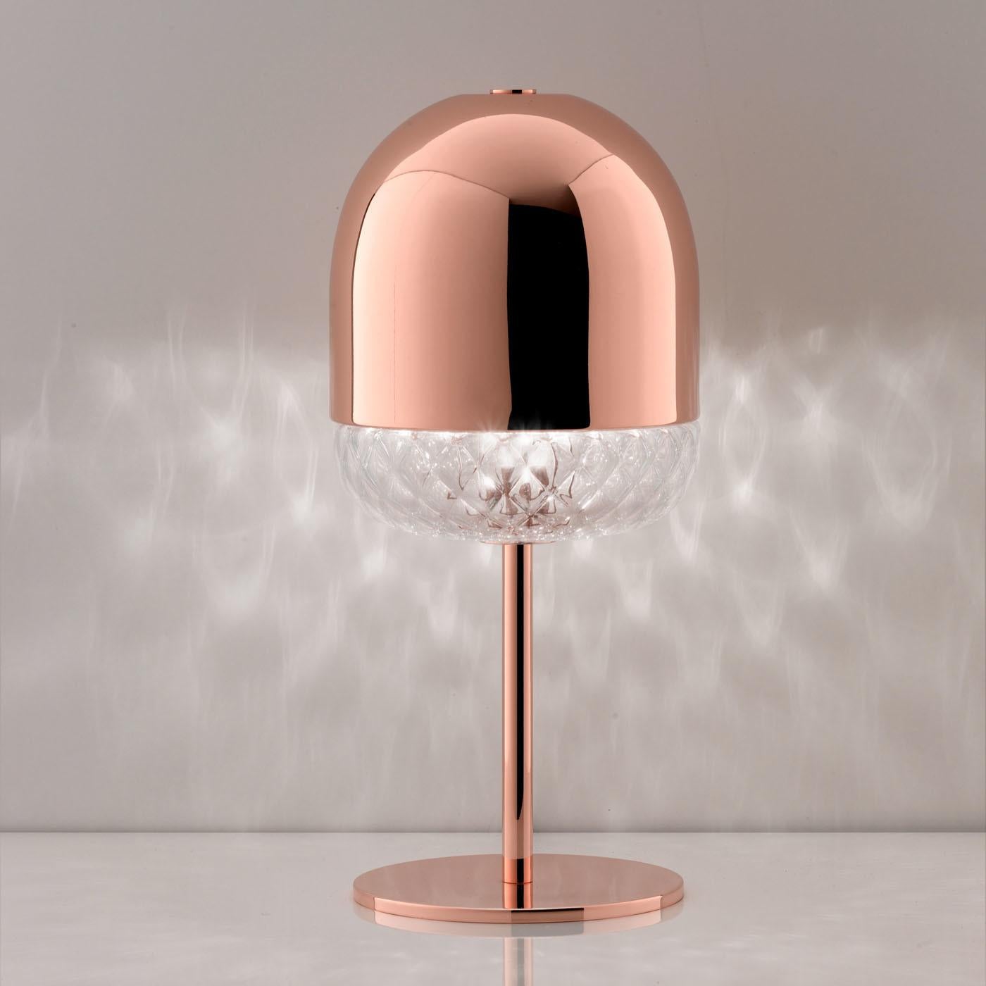 This elegant table lamp designed by Matteo Zorzenoni is inspired by one of the oldest Venetian glass-blowing techniques, the Balloton. The light pierces through the veins of the glass section that decorates the bottom of the shade. The top of the