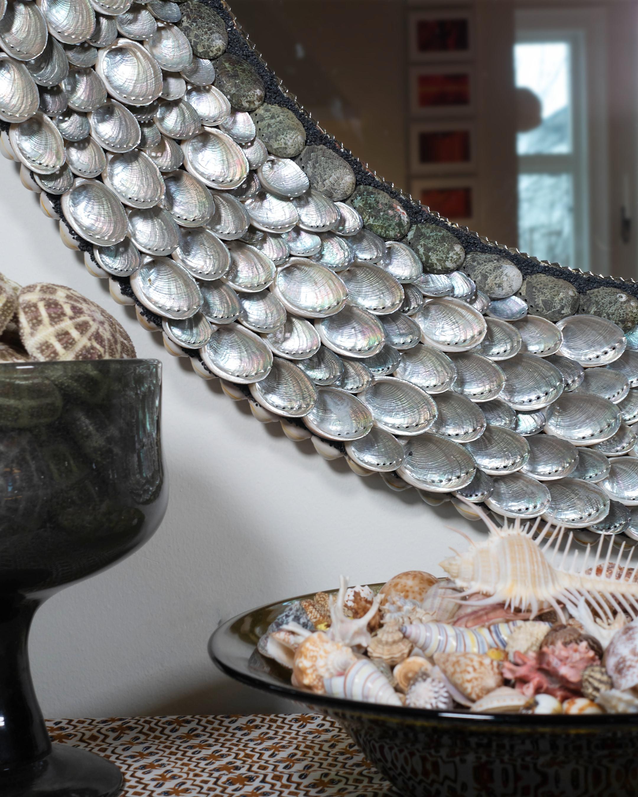 This is an elegant, shiny shell mirror (ø 102 cm) with a frame that continuously reflects the different lights in a day. “Ballroom Blitzz” is a first in a series of round mirrors where the two Shellman artists take advantage of the pearly inside of