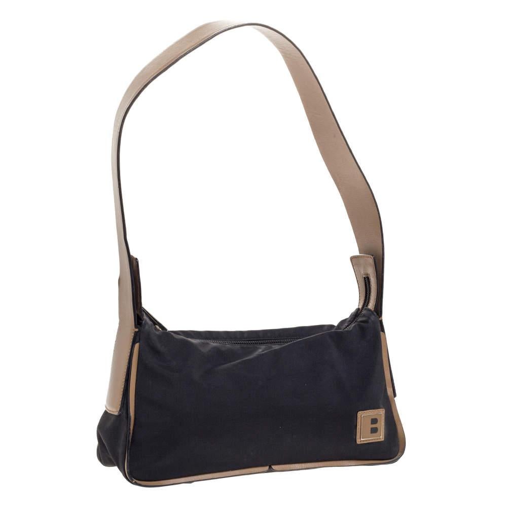 Ce sac en nylon et cuir magnifiquement cousu est signé Bally. Avec son intérieur spacieux doublé de toile, il accueillera bien plus que vos essentiels. Doté d'une poignée plate en cuir et d'une finition sans couture, ce sac offre style et praticité.