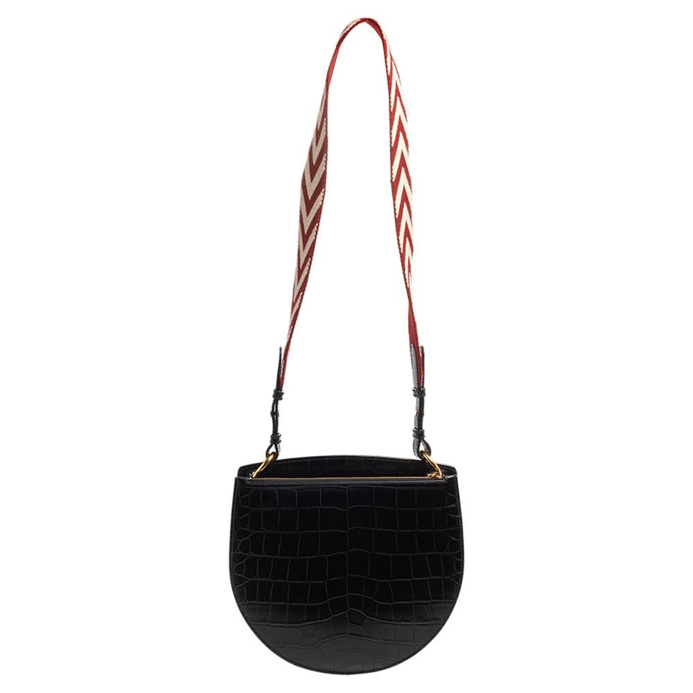 You are going to love owning this bag from Bally as it is well-made and brimming with luxury. The black creation has been crafted from croc-embossed leather featuring gold-tone hardware details. It opens to a canvas-lined spacious interior capable