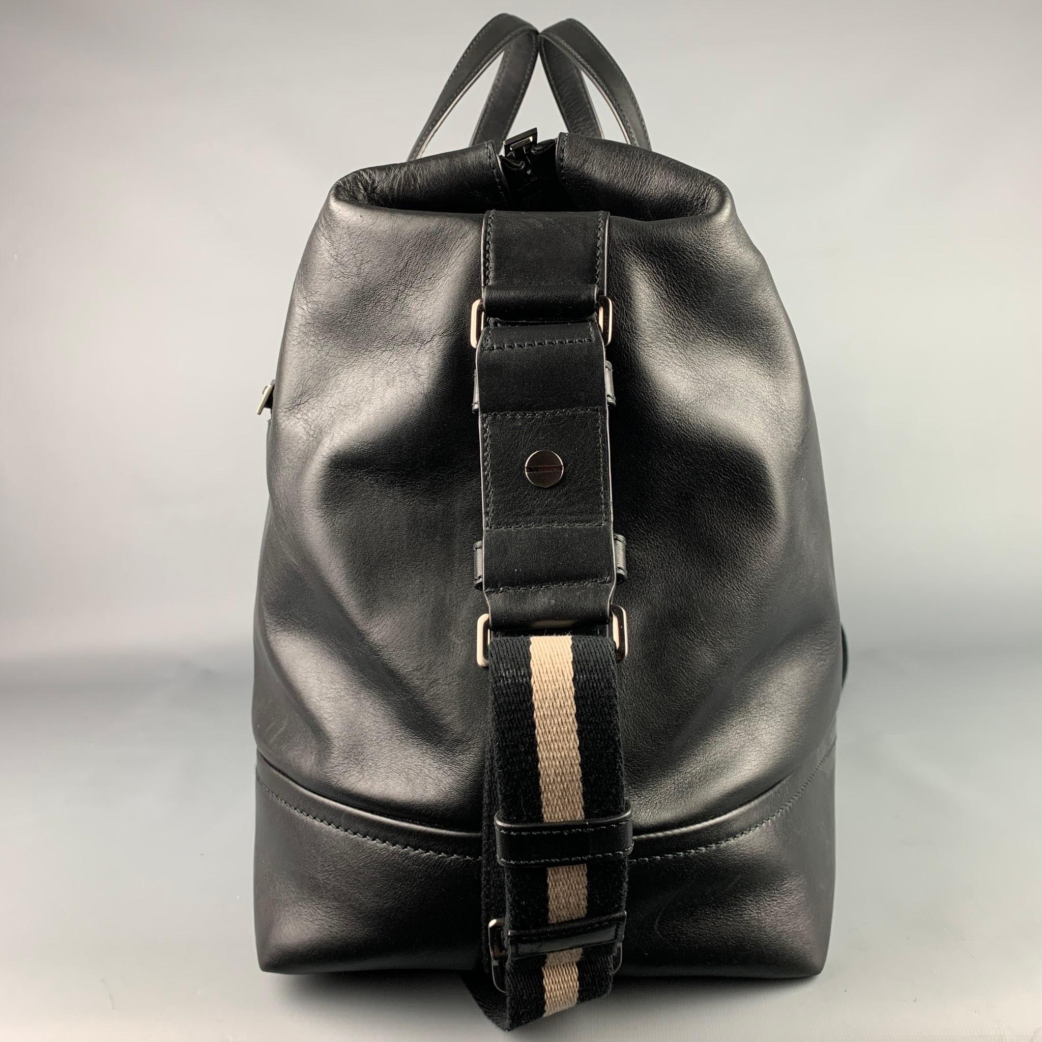 BALLY bag comes in a black leather featuring a duffle style, top handles, adjustable shoulder strap, front pocket, inner slots, and a zipper closure. 

Very Good Pre-Owned Condition.

Measurements:

Length: 19 in.
Width: 8.5 in.
Height: 12 in.
Drop: