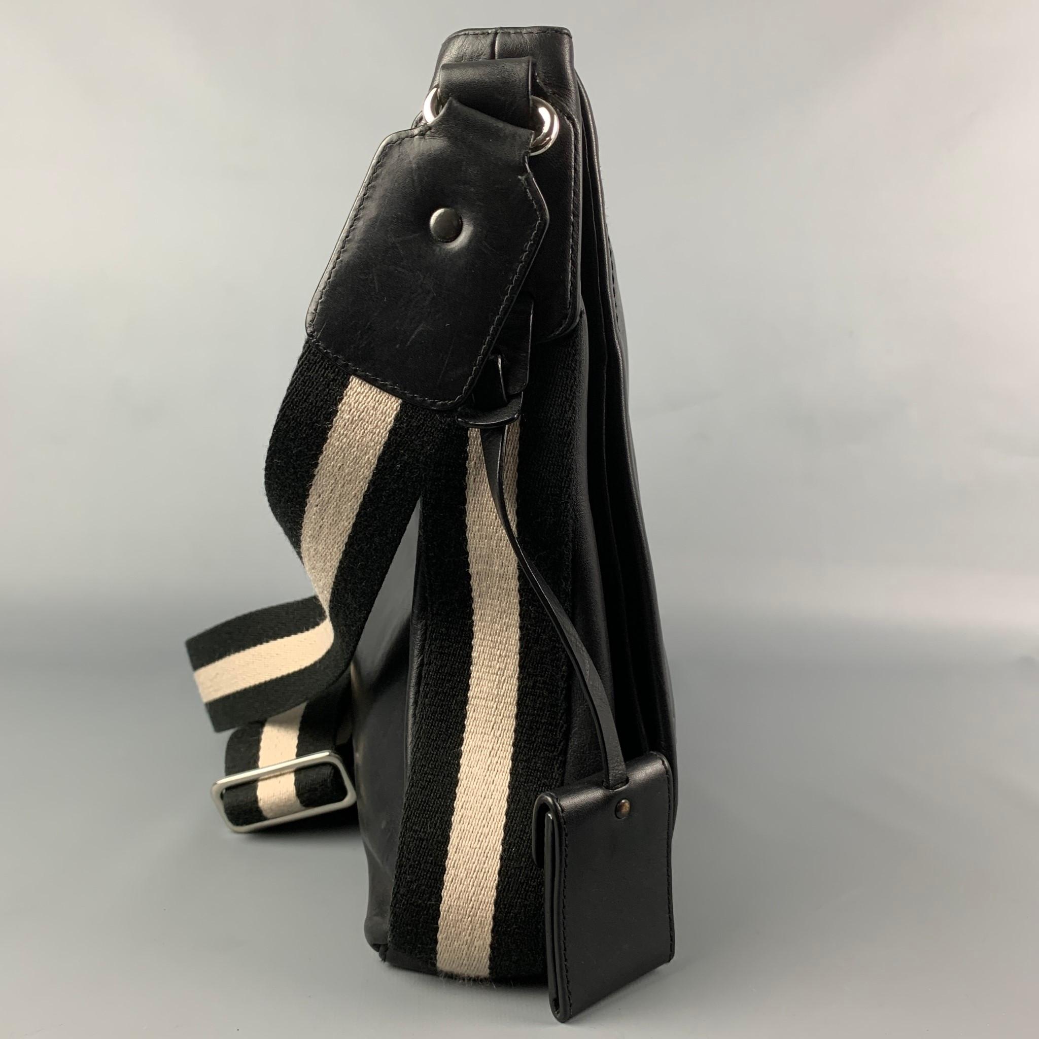 BALLY bag comes in a black leather featuring a messenger style, stripe trim, shoulder strap, silver tone hardware, front flap design, and inner pockets. 

Good Pre-Owned Condition.

Measurements:

Length: 12 in.
Width: 2.25 in.
Height: 12 in.
Drop: