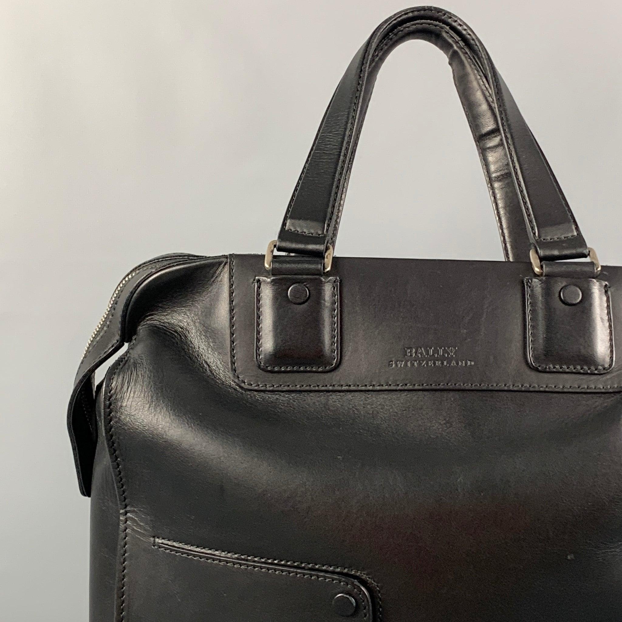 BALLY bag comes in a black leather featuring a tote style, top handles, front pockets, silver tone hardware, and a zipper closure.
Very Good
Pre-Owned Condition. Minor wear. As-is.  

Measurements: 
  Length:
14.25 inches Width: 7 inches Height: