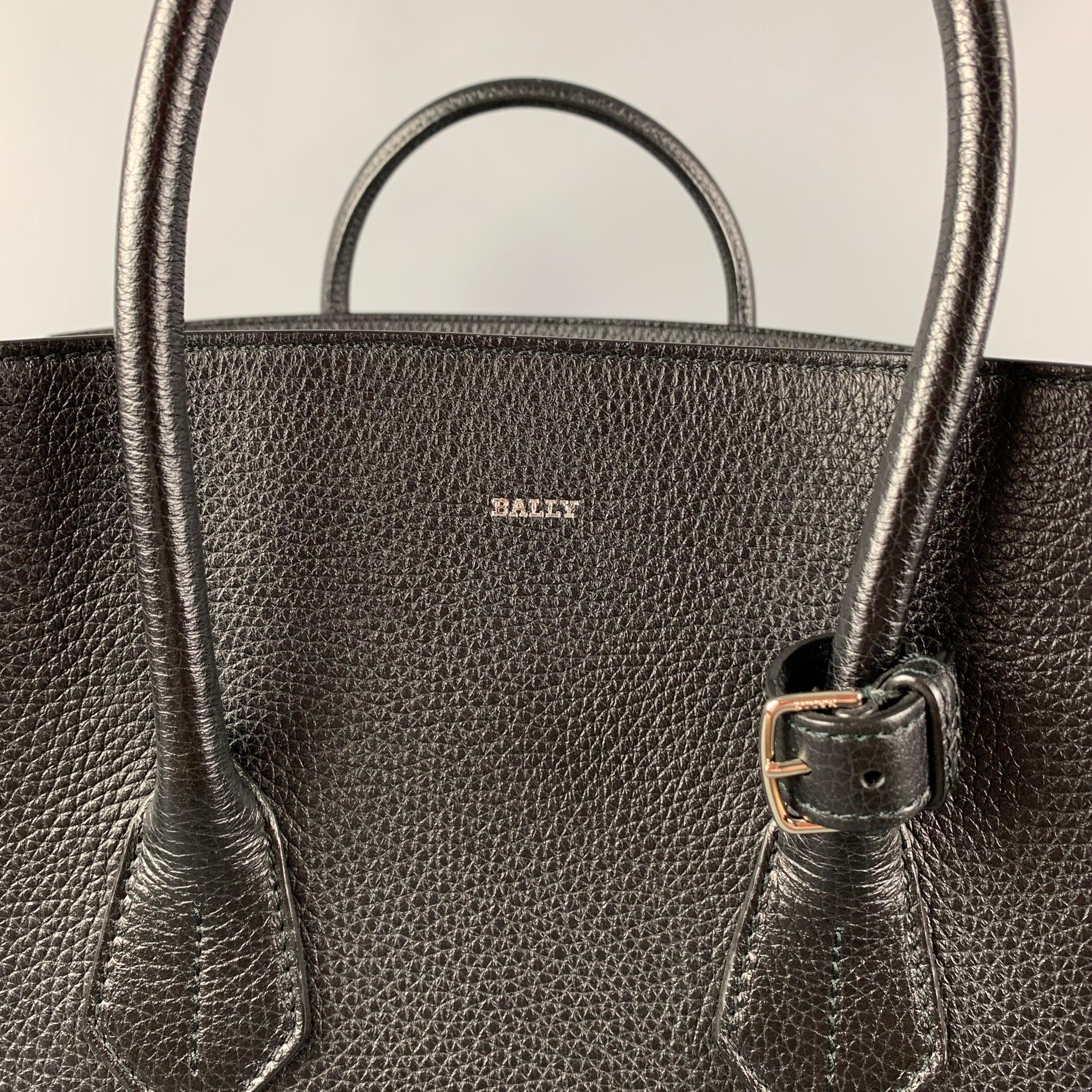 BALLY handbag comes in a black pebble grain leather with a salmon pink interior featuring top handles, inner pocket, and a top buckle strap closure. 

Very Good Pre-Owned Condition. Light wear around edges. As-is.

Measurements:

Length:15.5
