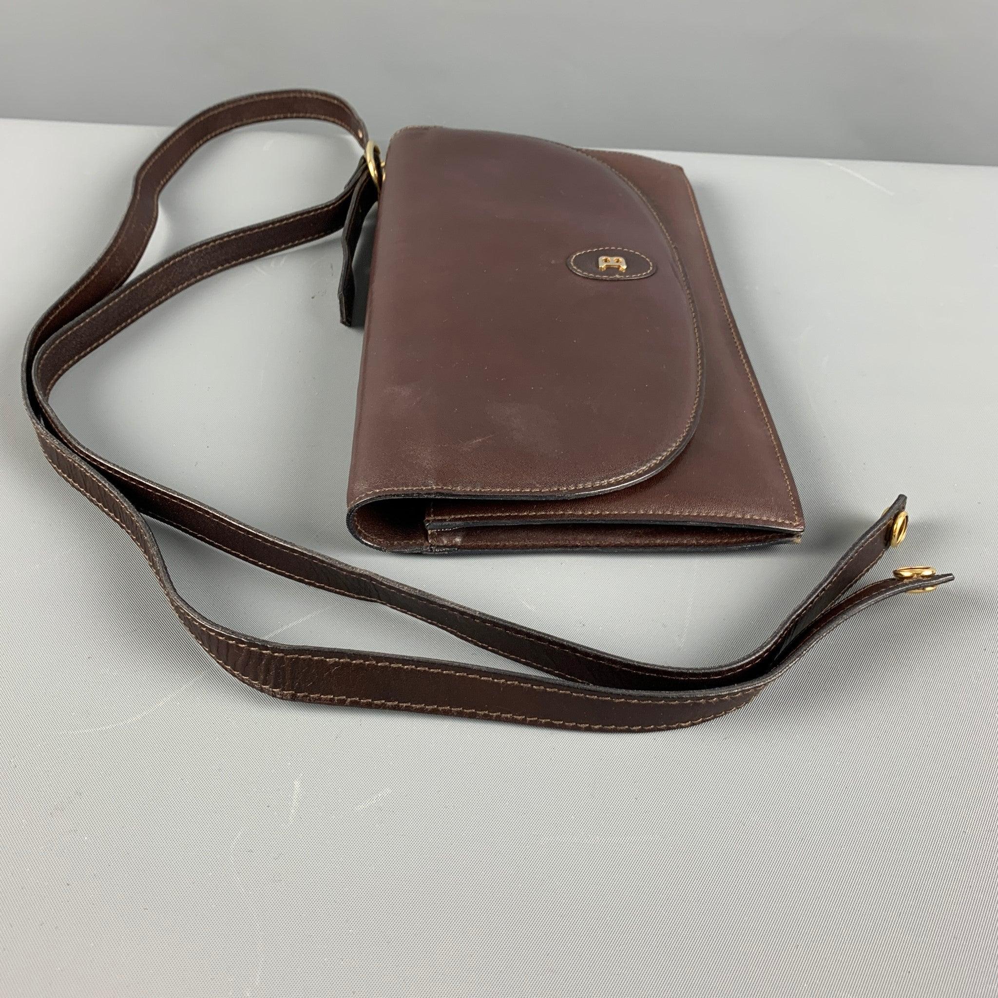 BALLY Vintage handbag comes in a brown leather featuring inner zipper pocket, single inner slot, and detachable strap. Comes with Dust Bag. Made in Italy.Very Good Pre-Owned Condition. Minor signs of wear. 

Measurements: 
  Length: 10 inches