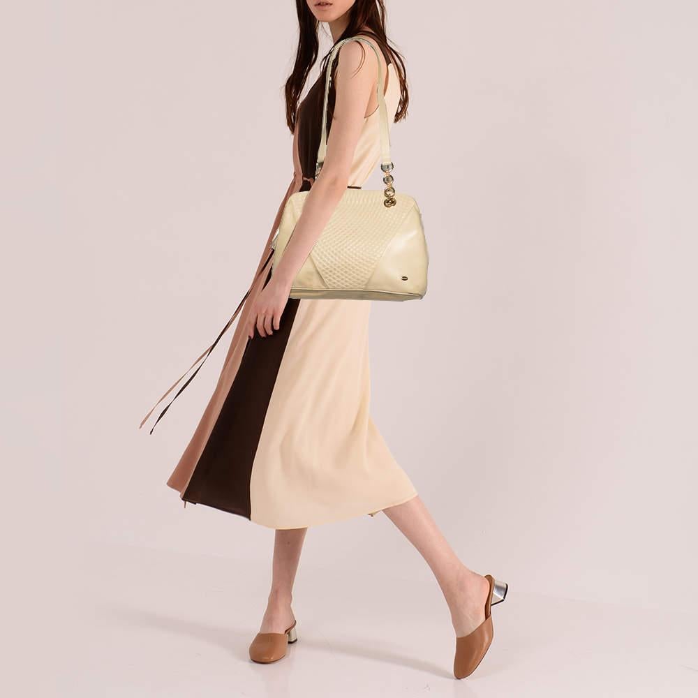 Elegance meets luxury in this bag from the House of Bally. It is created using cream quilted leather, highlighted with fringe detailing. It has a leather-lined interior, gold-tone hardware, and a shoulder chain. This bag will elevate your look