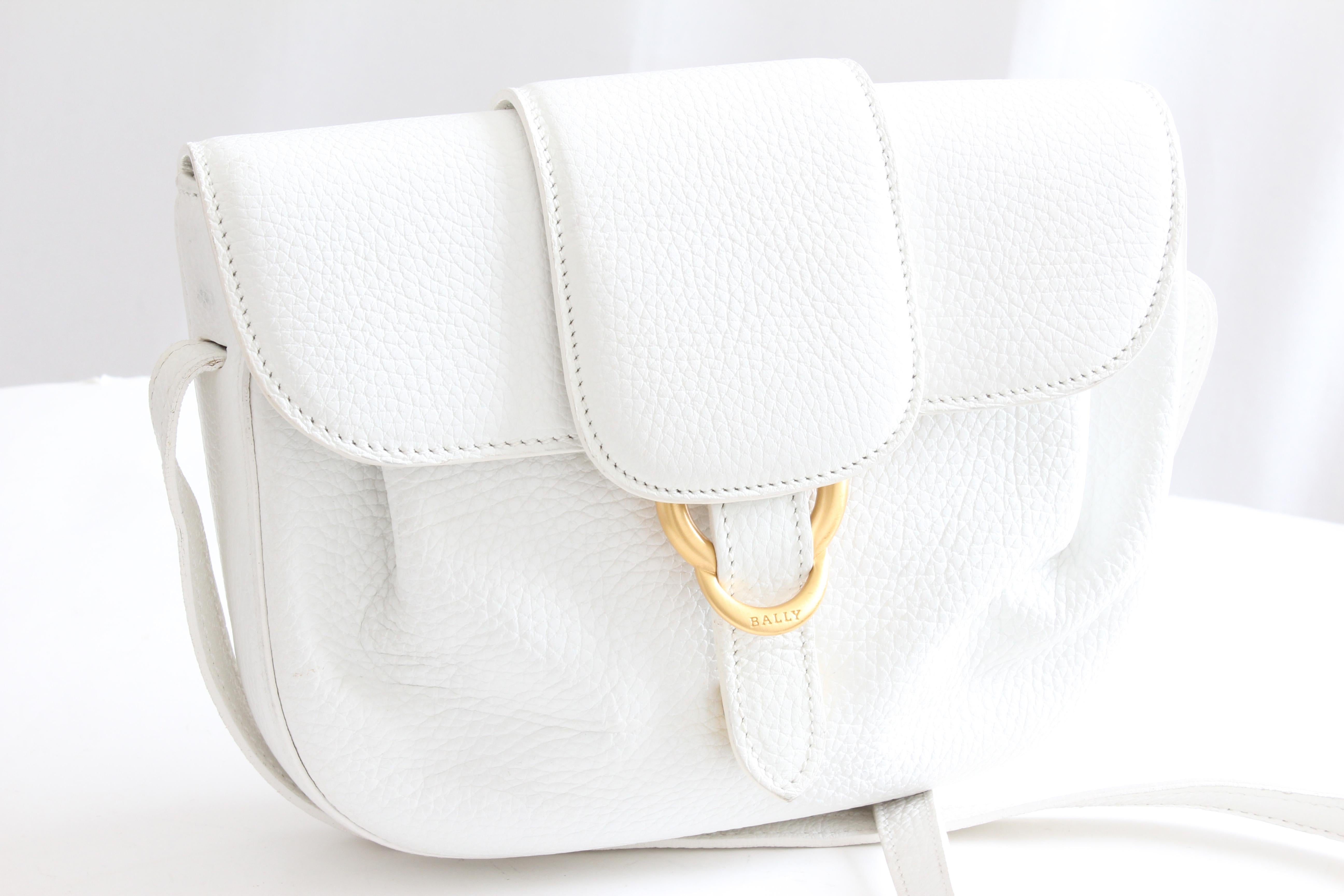 This chic little bag was made by Bally, likely in the early 2000s.  Made from white pebbled leather, it features an adjustable strap, allowing one to wear crossbody or on shoulder.  The interior features two compartments and one zipper pocket.  

A