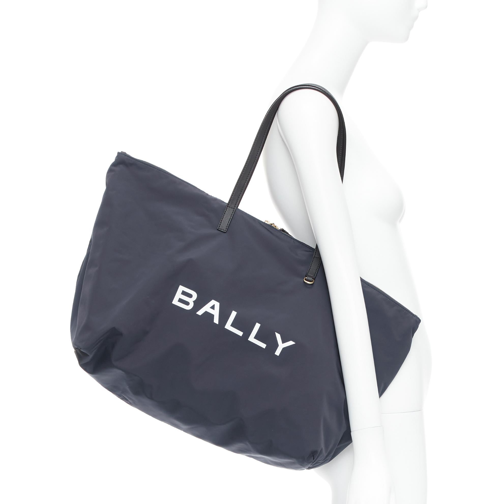 BALLY navy nylon white logo travel luggage foldable shoulder tote bag
Reference: TGAS/E00482
Brand: Bally
Material: Nylon, Leather
Color: Navy, White
Pattern: Solid
Closure: Zip
Lining: Black Fabric
Extra Details: Navy blue. Technical jersey.