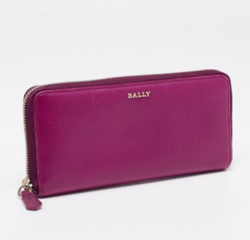 La duradera fabricación en piel de esta cartera la convierte en un accesorio fiable. Esta fina cartera presenta un gran tono morado y una cremallera para asegurar el bien equipado interior. Esta creación de Bally puede caber fácilmente en tus bolsos