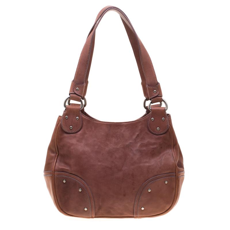 Bally showcases a masterfully designed handbag from its collection of accessories. Crafted from fancy leather, this would let you flaunt the latest fashion. It has a canvas lined interior offering enough storage for everyday essentials. Tan in