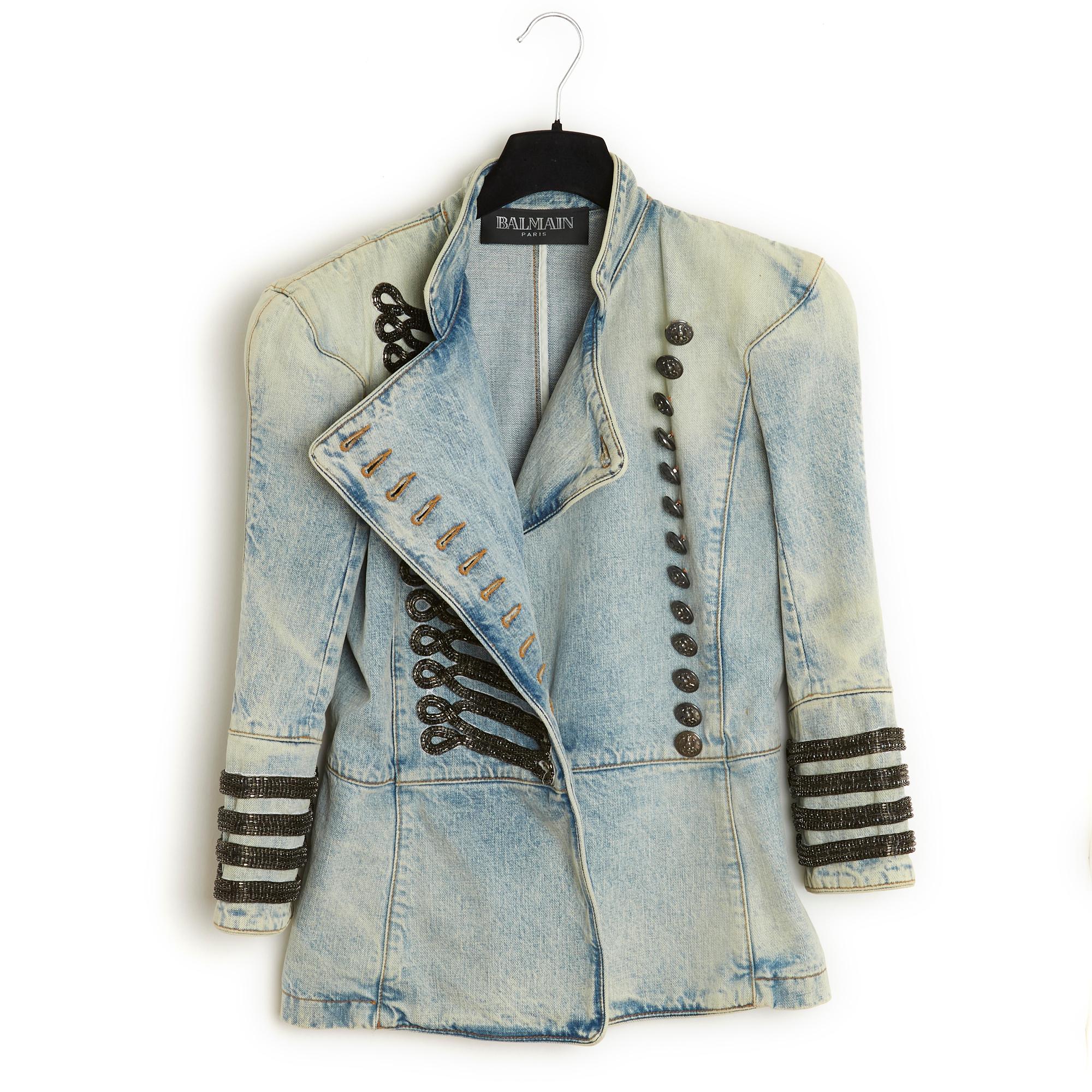 Giacca Balmain collezione SS2009 di Christopher Decarnin, di ispirazione militare, in denim lavato, piccolo collo alto, pettorina decorata con passamaneria a catena in metallo annerito chiusa da 13 bottoni di marca, spalline, maniche a 2/3 spacchi