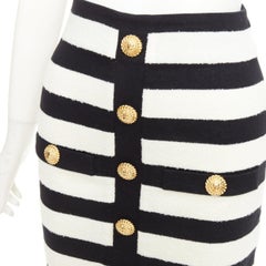 BALMAIN 2024: Zweifarbiger, gestreifter Midirock aus Strick im Bleistift-Schnitt mit hoher Taille und Löwenknöpfen an der Vorderseite