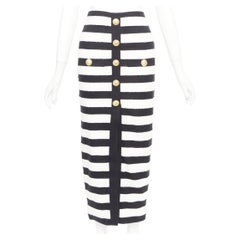 BALMAIN 2024: Zweifarbiger, gestreifter Midirock aus Strick im Bleistift-Schnitt mit hoher Taille und Löwenknöpfen an der Vorderseite