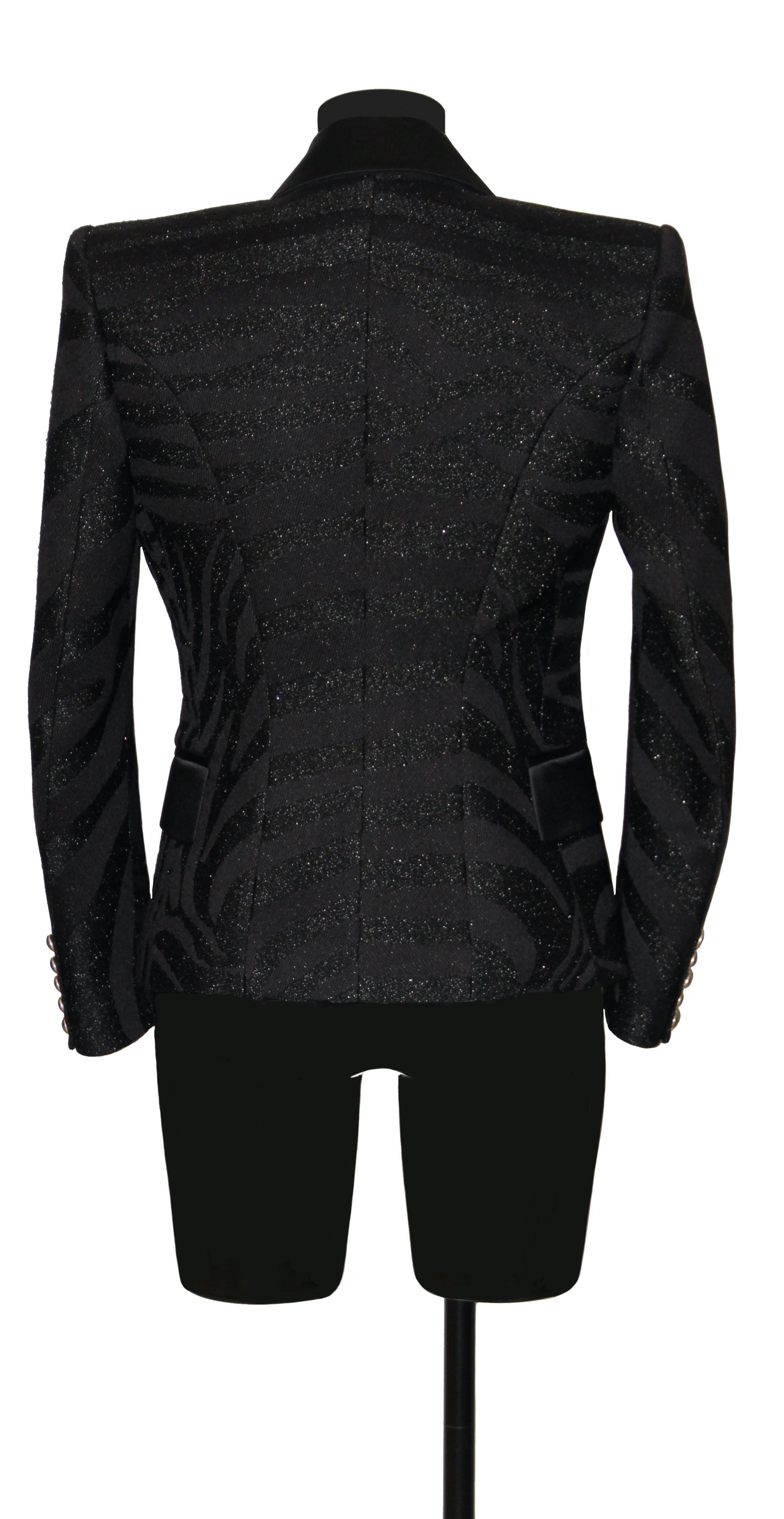 This black jacket is now a classic from the house of Balmain. 
It is slightly fitted for and single breasted with a beautiful metal button / lion's head as a closure.
Smaller matching buttons (x5) on each sleeve.
Lapels and flat pockets are in balck